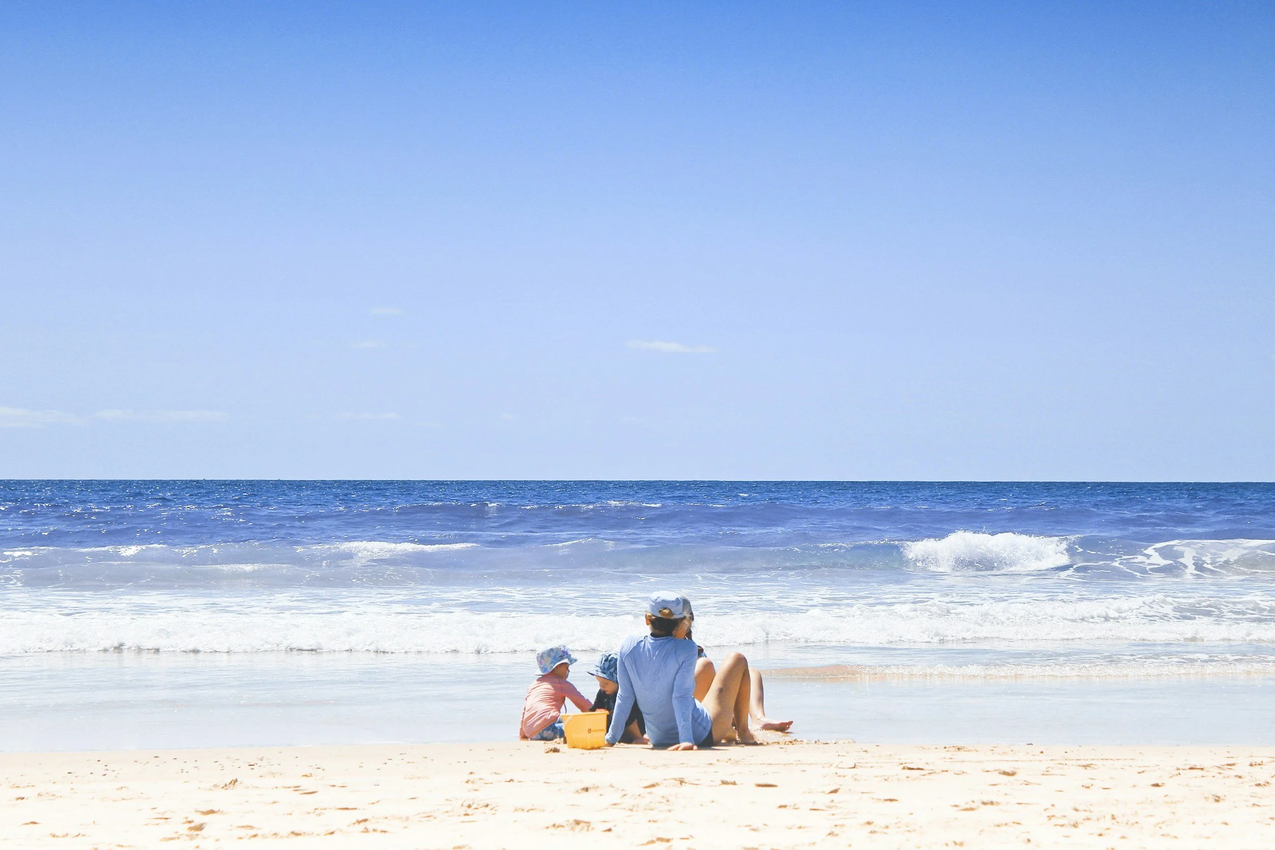 Family enjoying time together on a sunny beach, representing family vacation experiences.