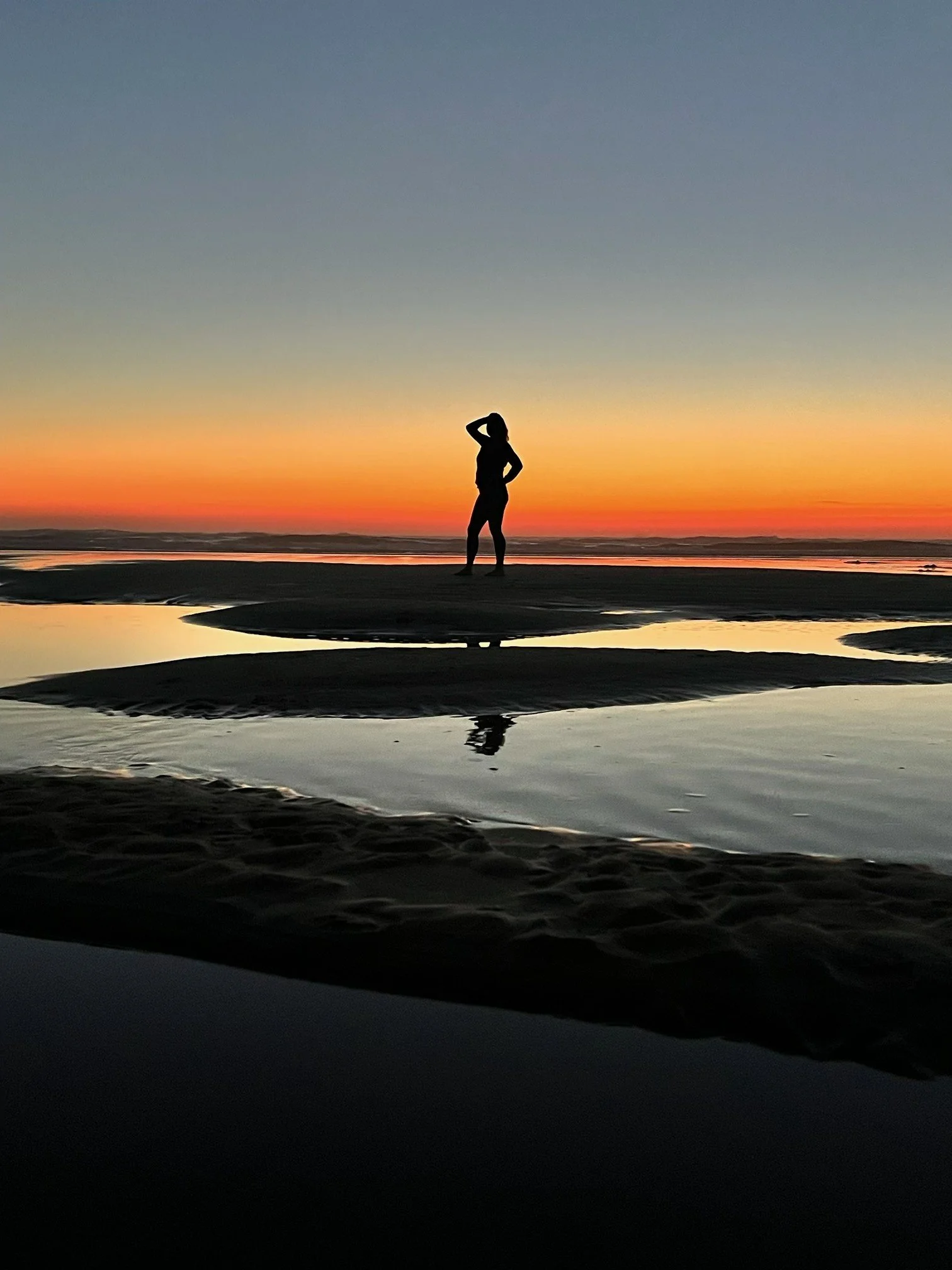 Solo traveler enjoying a peaceful beach sunset.