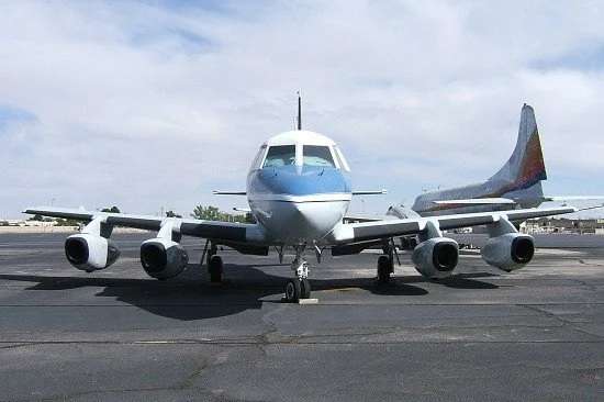 Front view of a commercial airplane parked on an airport tarmac.