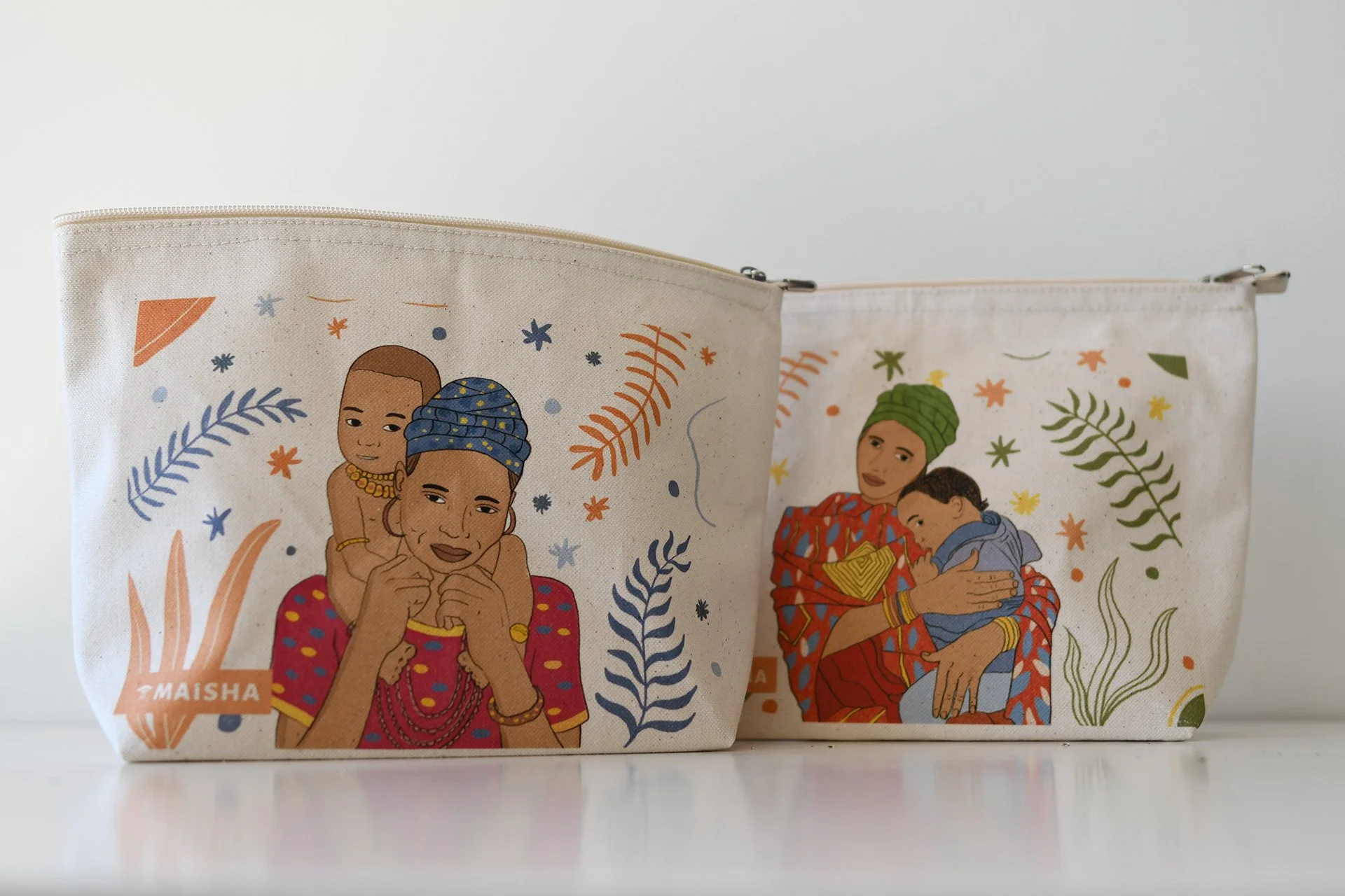 Dos bolsas con ilustraciones de personas de diferentes culturas, rodeadas de hojas y elementos decorativos coloridos.