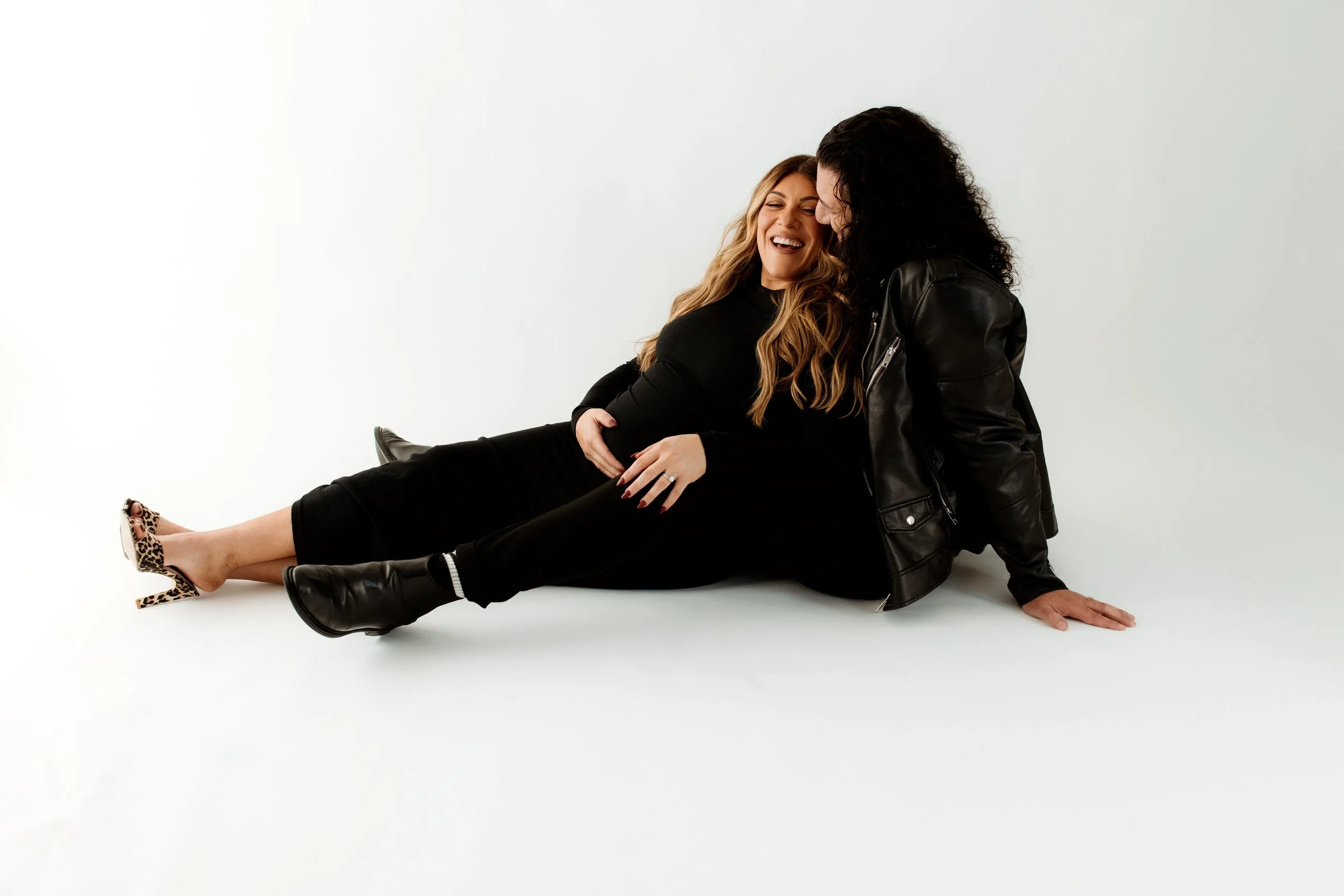 Editorial maternity photography in Melbourne featuring a pregnant couple sharing a joyful moment in a bright, minimalist studio.