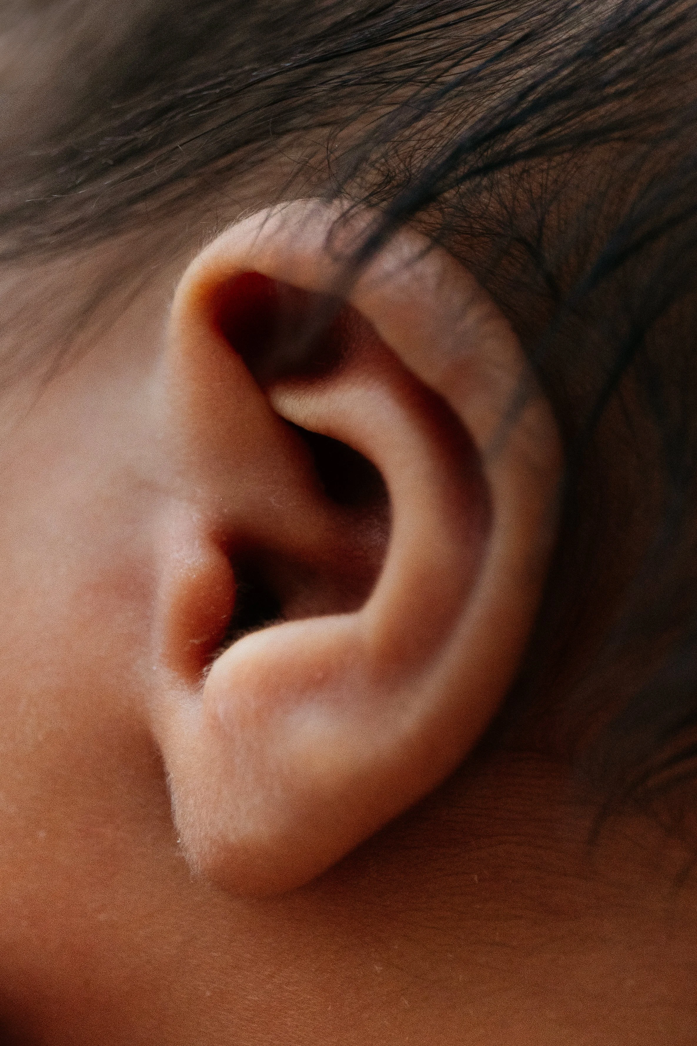 A close-up of a person's ear and hair.