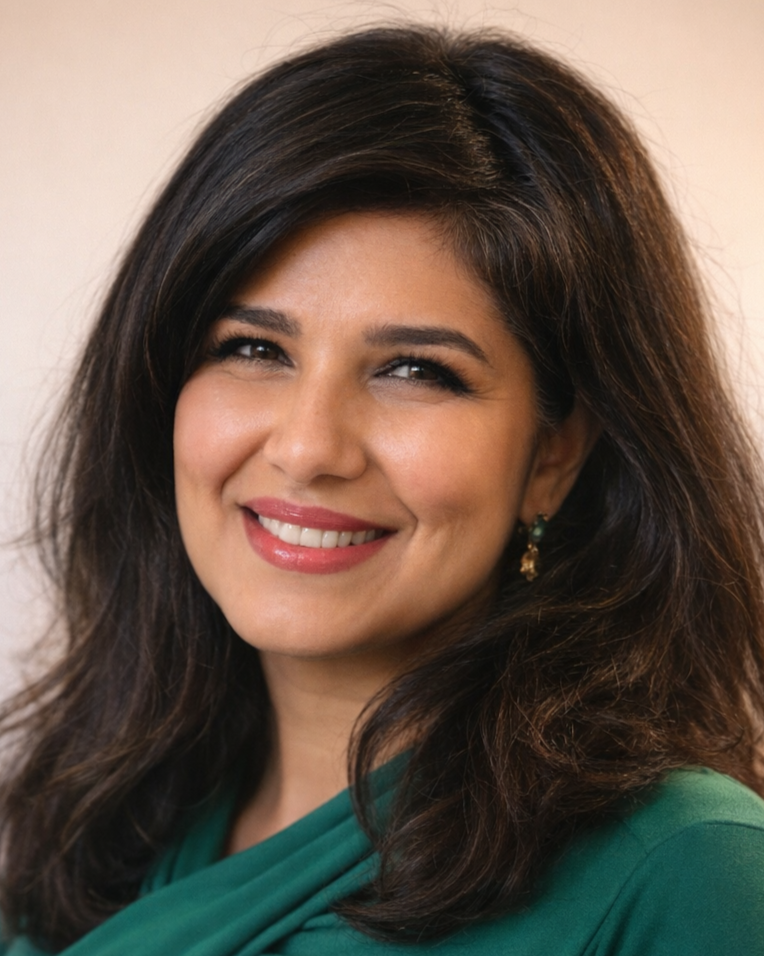 A woman, Dr. Darshana Lele, with shoulder-length dark brown hair wearing a green top, smiling at the camera.