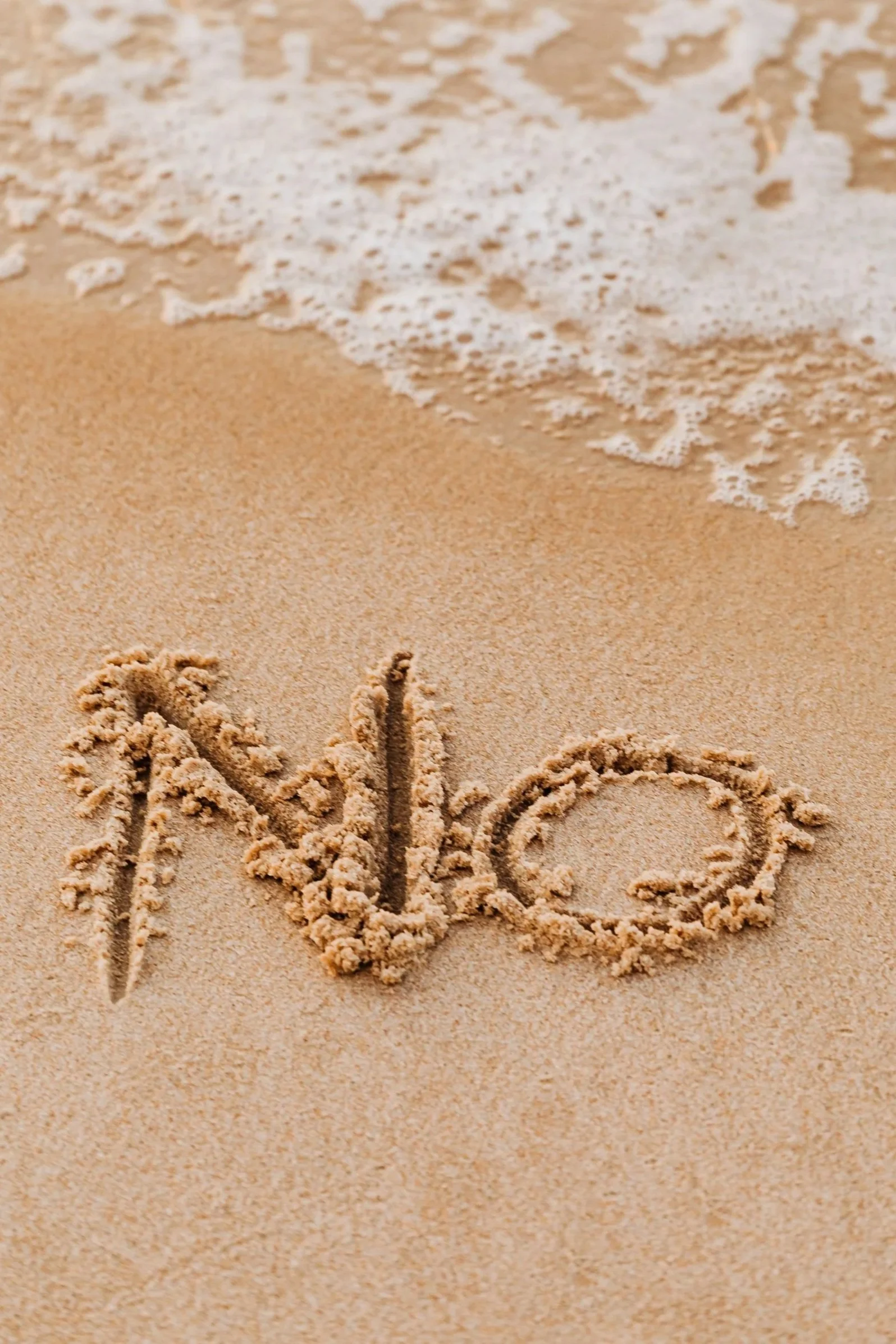 Writing in the sand spells out the word 'No'
