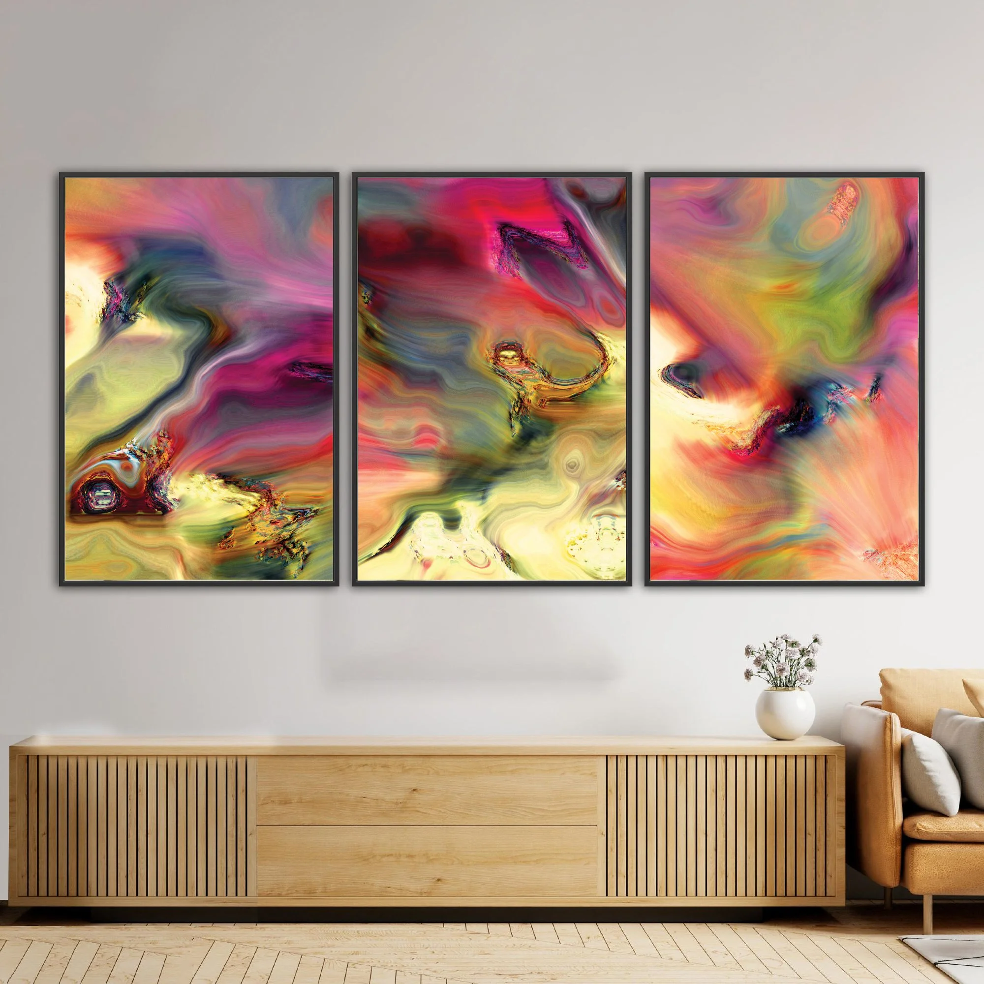 Abstract fine art triptych with swirling psychedelic liquid marble textures in vibrant magenta, ocher yellow, and wine red tones over a warm background, framed and ready to hang. Over wooden console