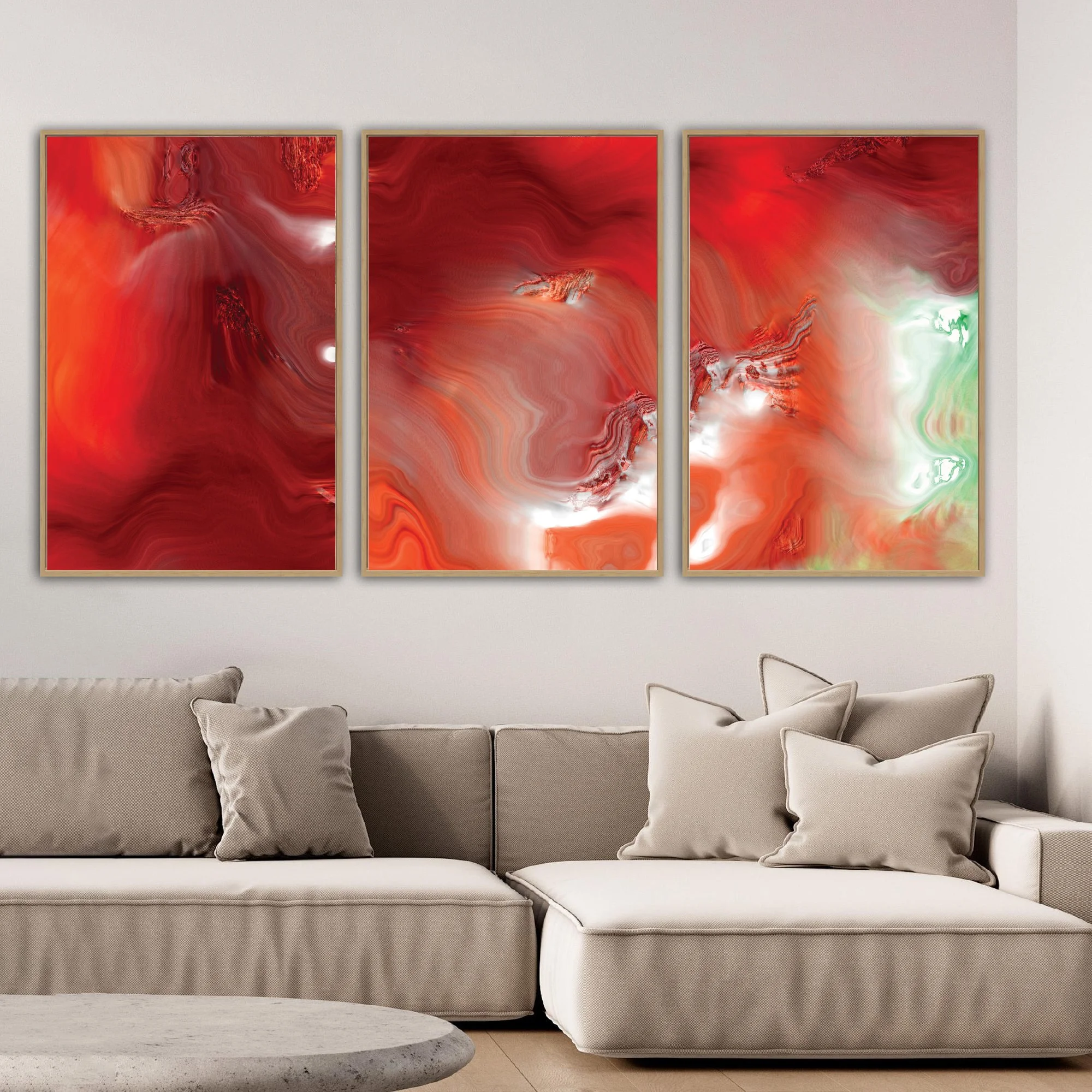 Abstract fine art triptych with dense, flowing liquid marble textures in vibrant crimson red, burgundy, and coral orange, white highlights and light green, framed and ready to hang. Over grey couch