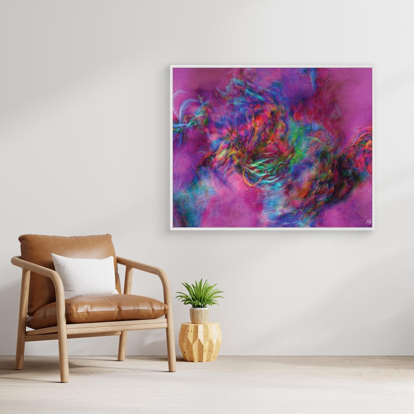 Abstract fine art print with heavy plaster-like texture featuring a vibrant magenta and pink background with a colorful swirling center, framed and ready to hang. With chair