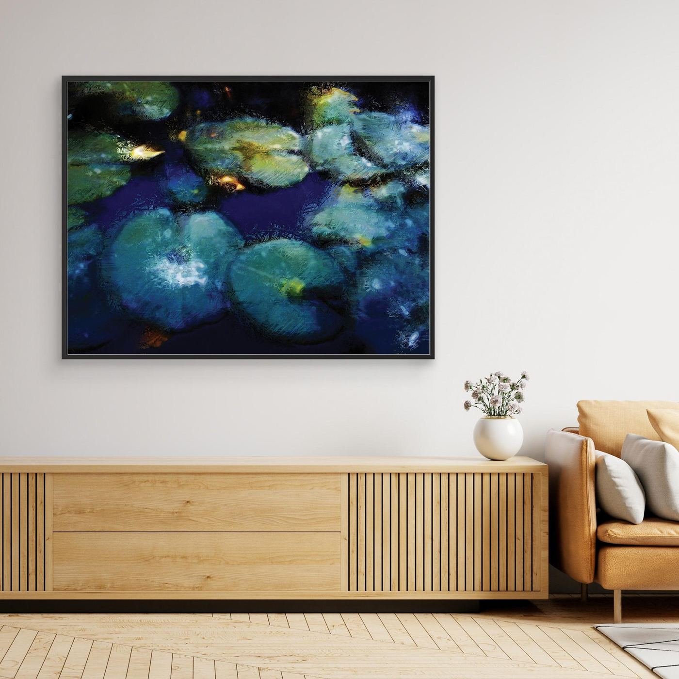 Abstract fine art print evoking a serene pond with lily pads in deep blue, teal, and green tones with impressionistic light textures, framed and ready to hang. Over wooden console