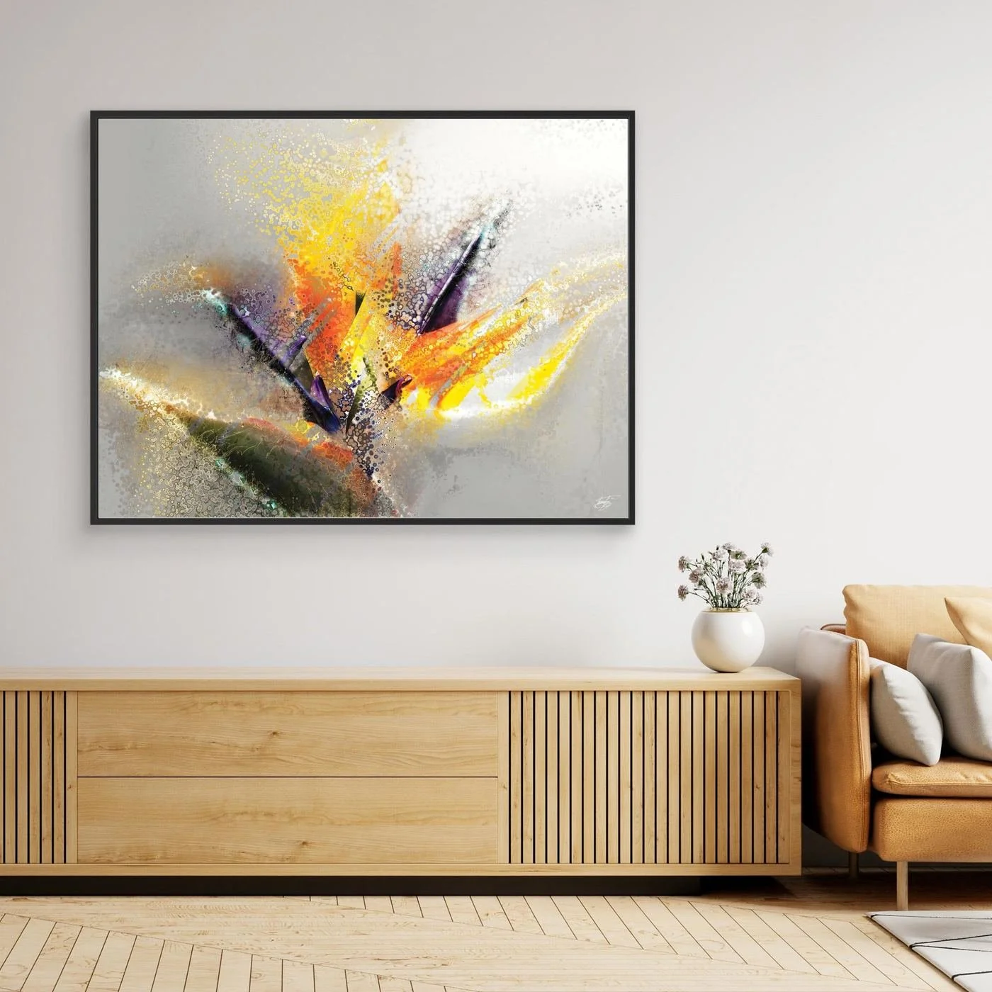 Abstract fine art print evoking an exotic flower with stipple and splash textures in vibrant yellow, orange, and purple over a light gray background, framed and ready to hang. Over wooden console