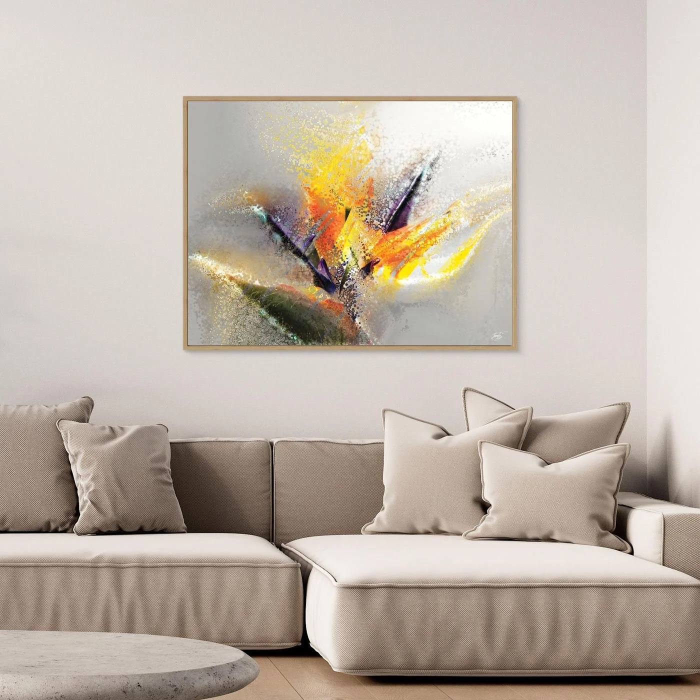 Abstract fine art print evoking an exotic flower with stipple and splash textures in vibrant yellow, orange, and purple over a light gray background, framed and ready to hang. Over grey couch