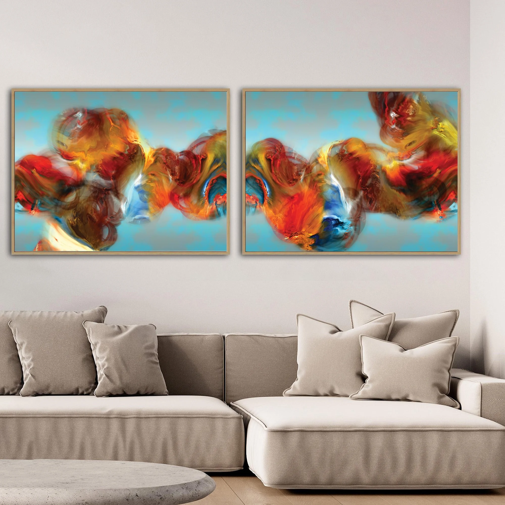 Abstract diptych with textured, cloud-like fluid shapes in red, orange, and golden ocher against a cerulean sky blue background, framed and ready to hang. Over grey couch