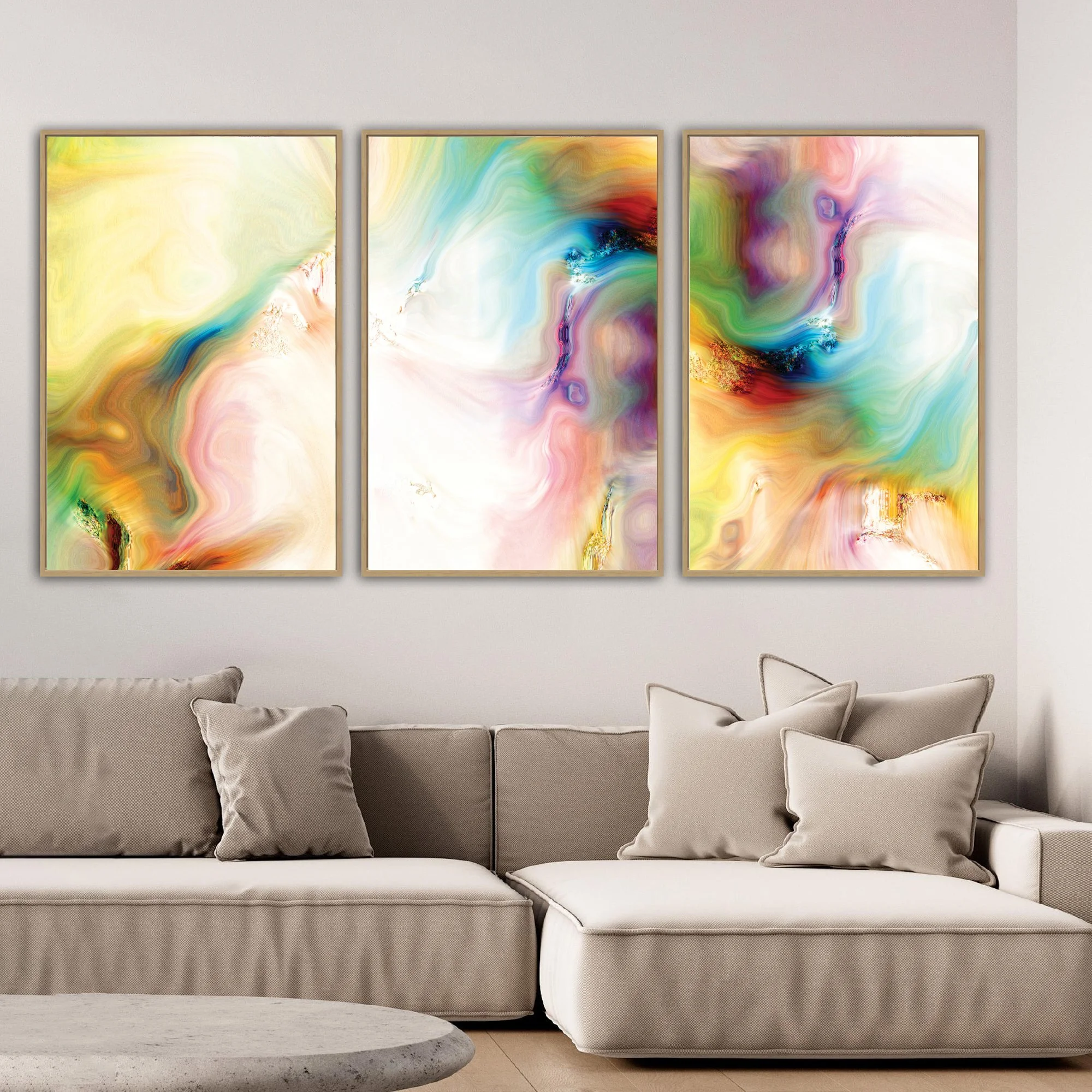 Abstract fine art triptych with textures and swirls in  yellow, green, turquoise, and pink with gold accents on a white background, framed and ready to hang. Over grey couch