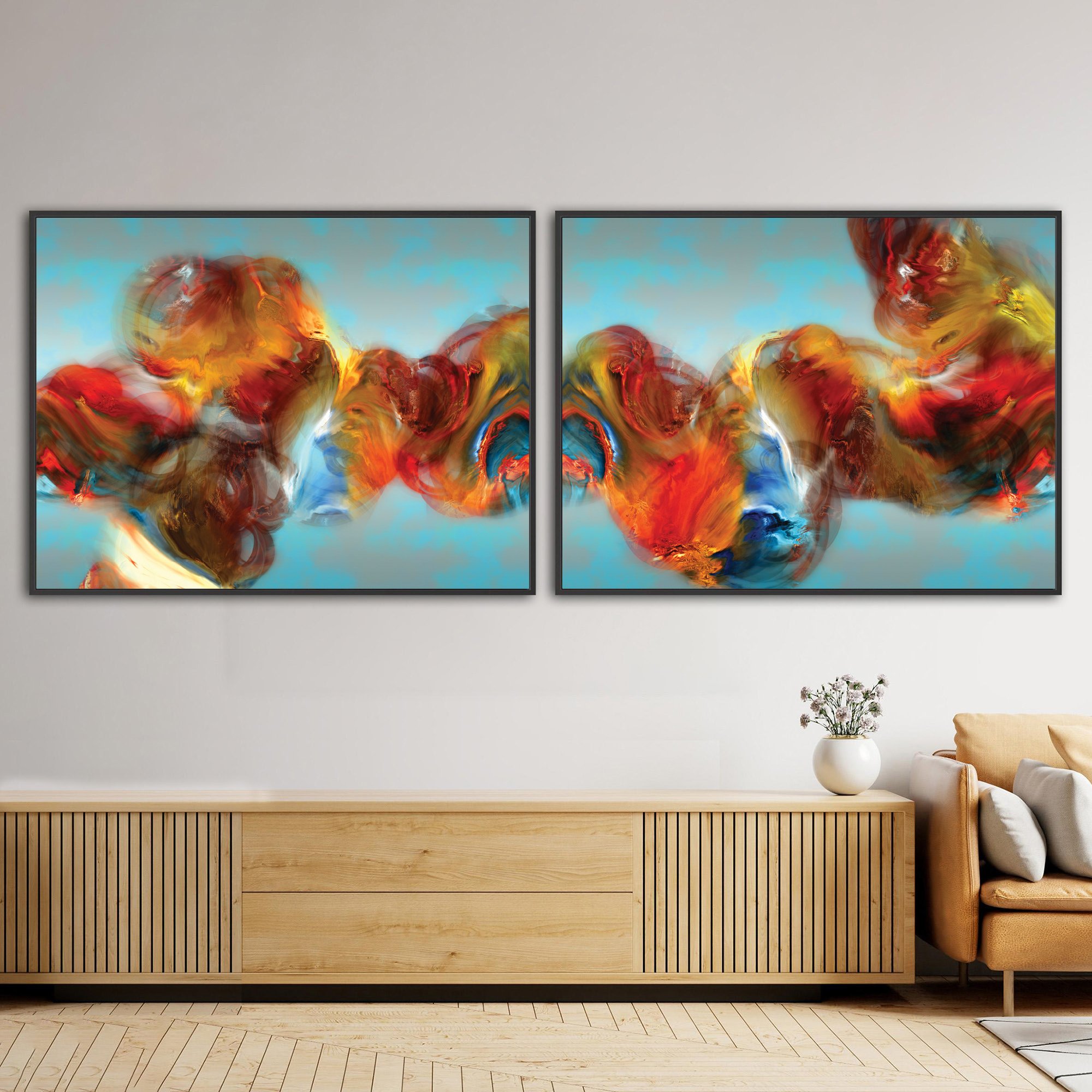 Abstract diptych with textured, cloud-like fluid shapes in red, orange, and golden ocher against a cerulean sky blue background, framed and ready to hang. Over wooden console