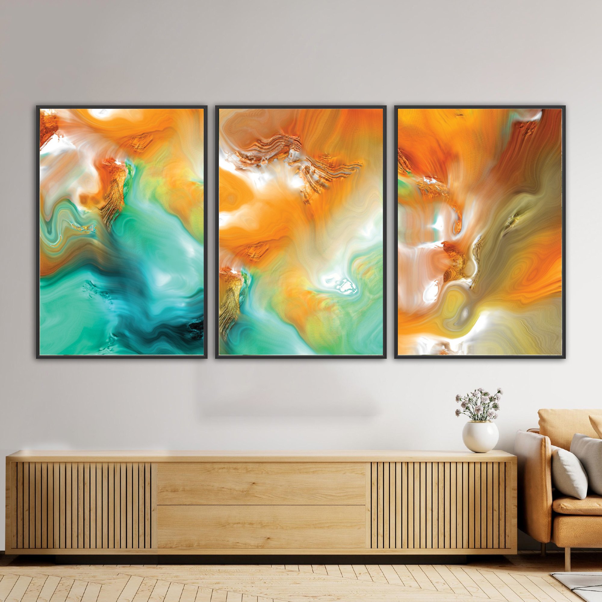 Abstract fine art triptych with flowing liquid marble textures in orange, ocher, and teal green tones, over a bright background, framed and ready to hang. Over wooden console