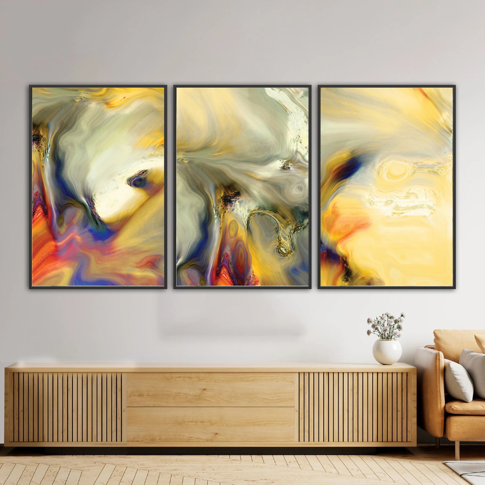 Abstract triptych with liquid textures in warm gold, ocher, and cream, contrasting with deep navy blue and terracotta swirls, framed and ready to hang. Over wooden console