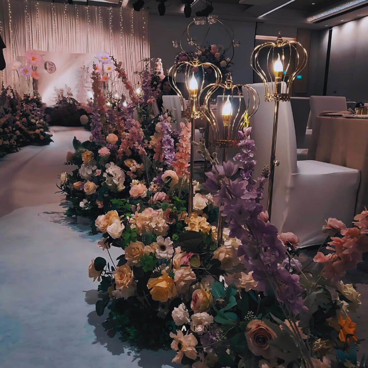 Elegant event space with floral arrangements, decorative lighting, and formal dining setup for a wedding or celebration.