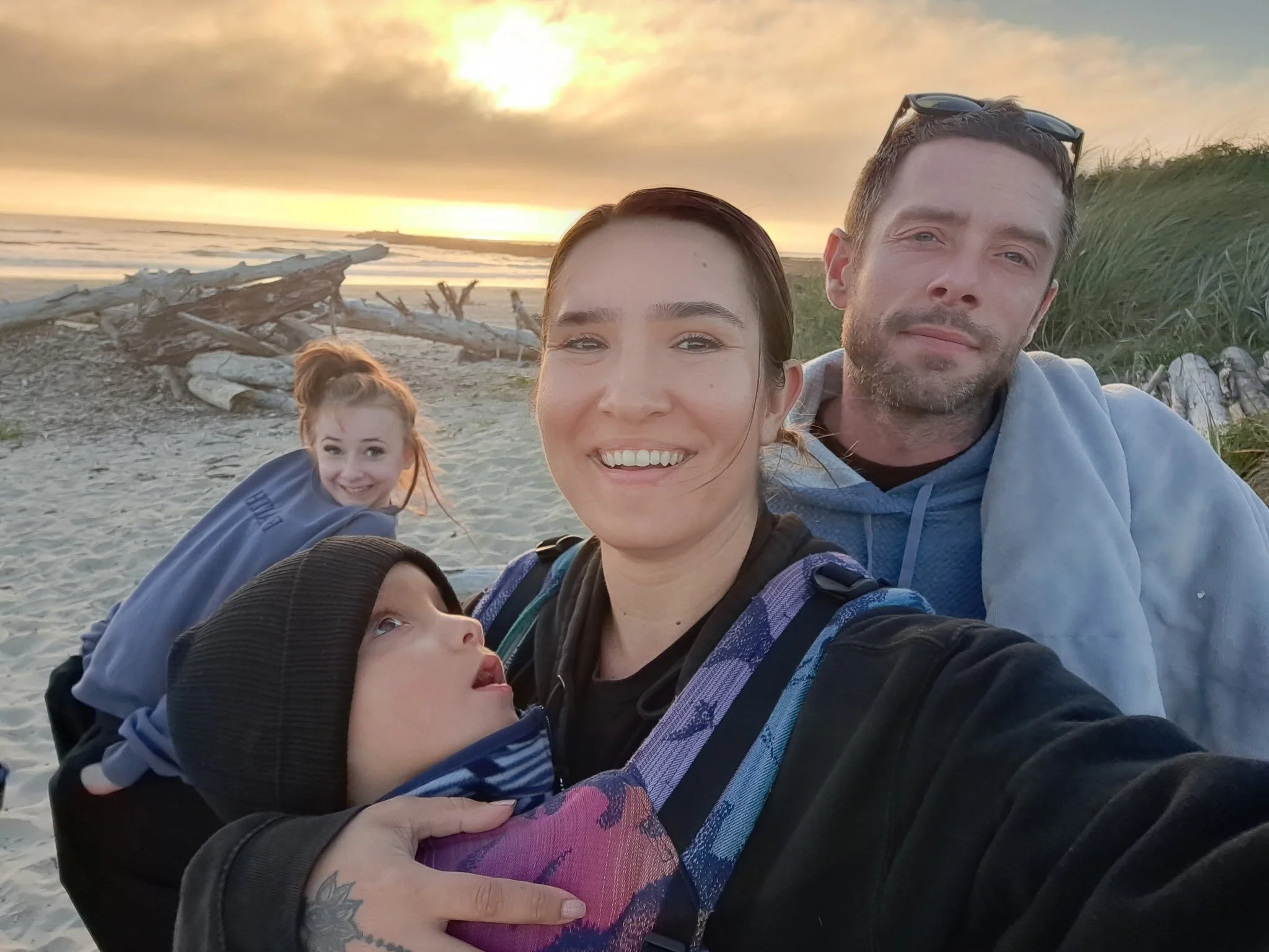 Silas with his family at the beach at sunset