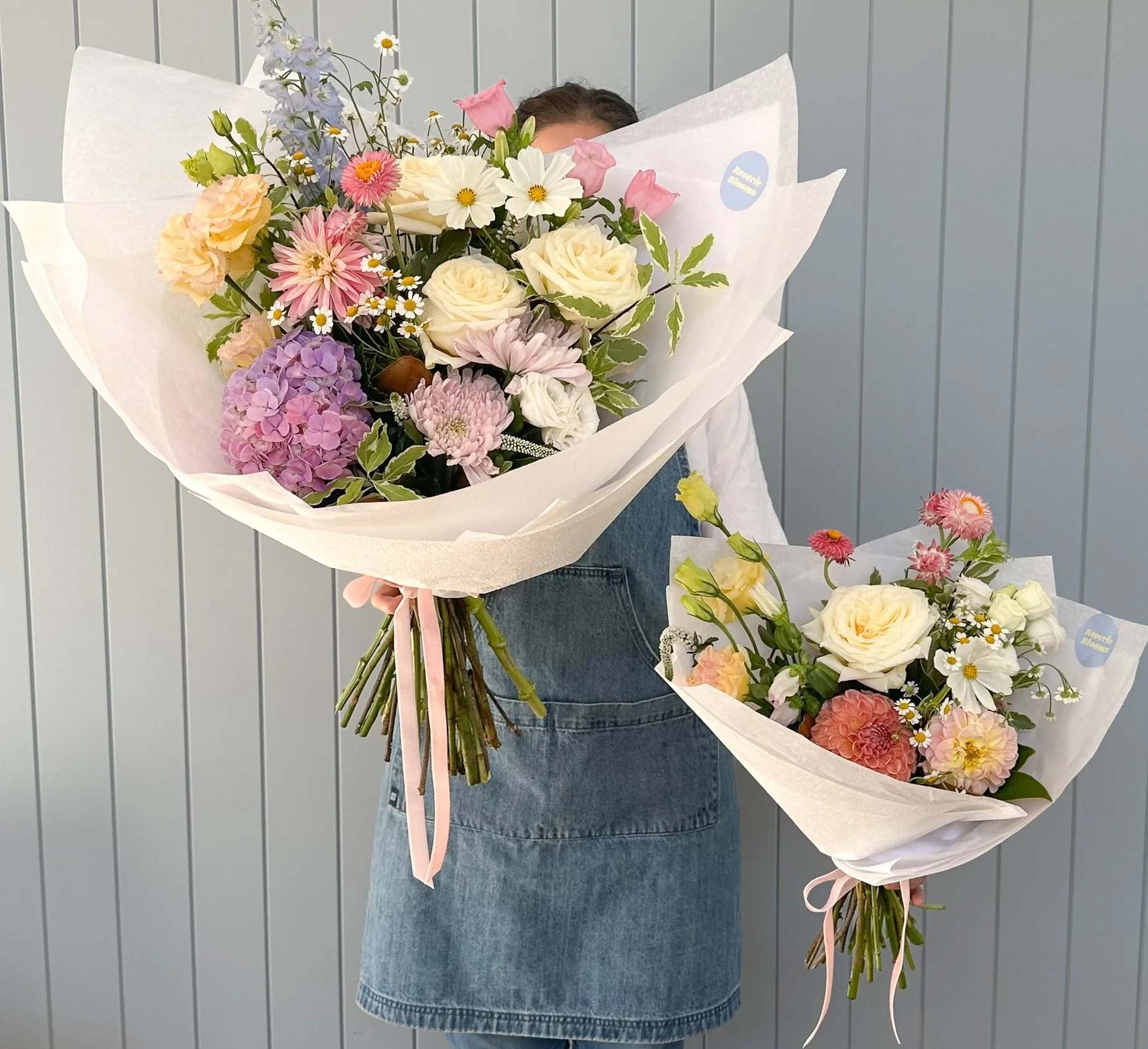 reverie-blooms-florist-holding-two-pastel-bouquets.jpg