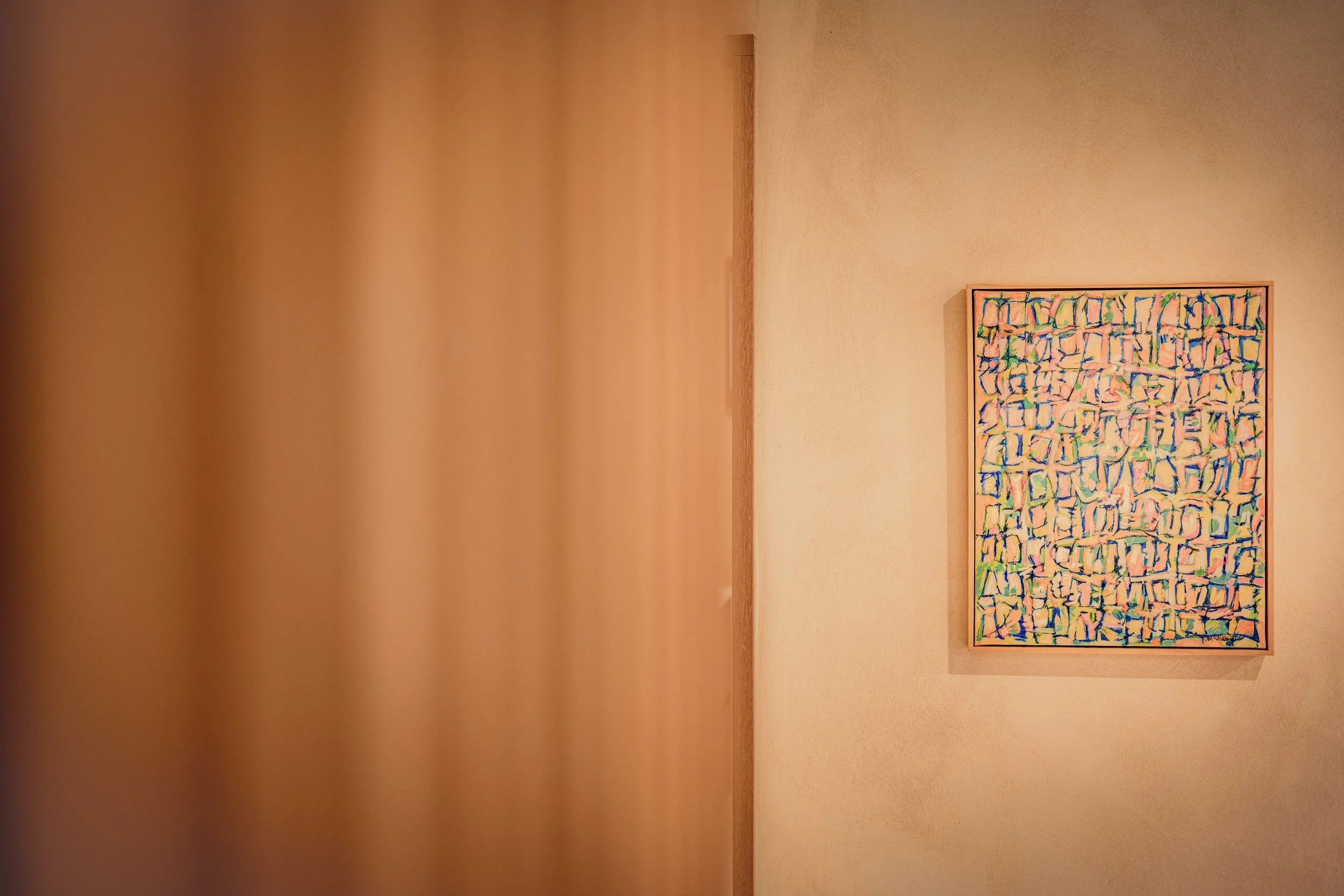 Abstract painting on a lime-washed wall.