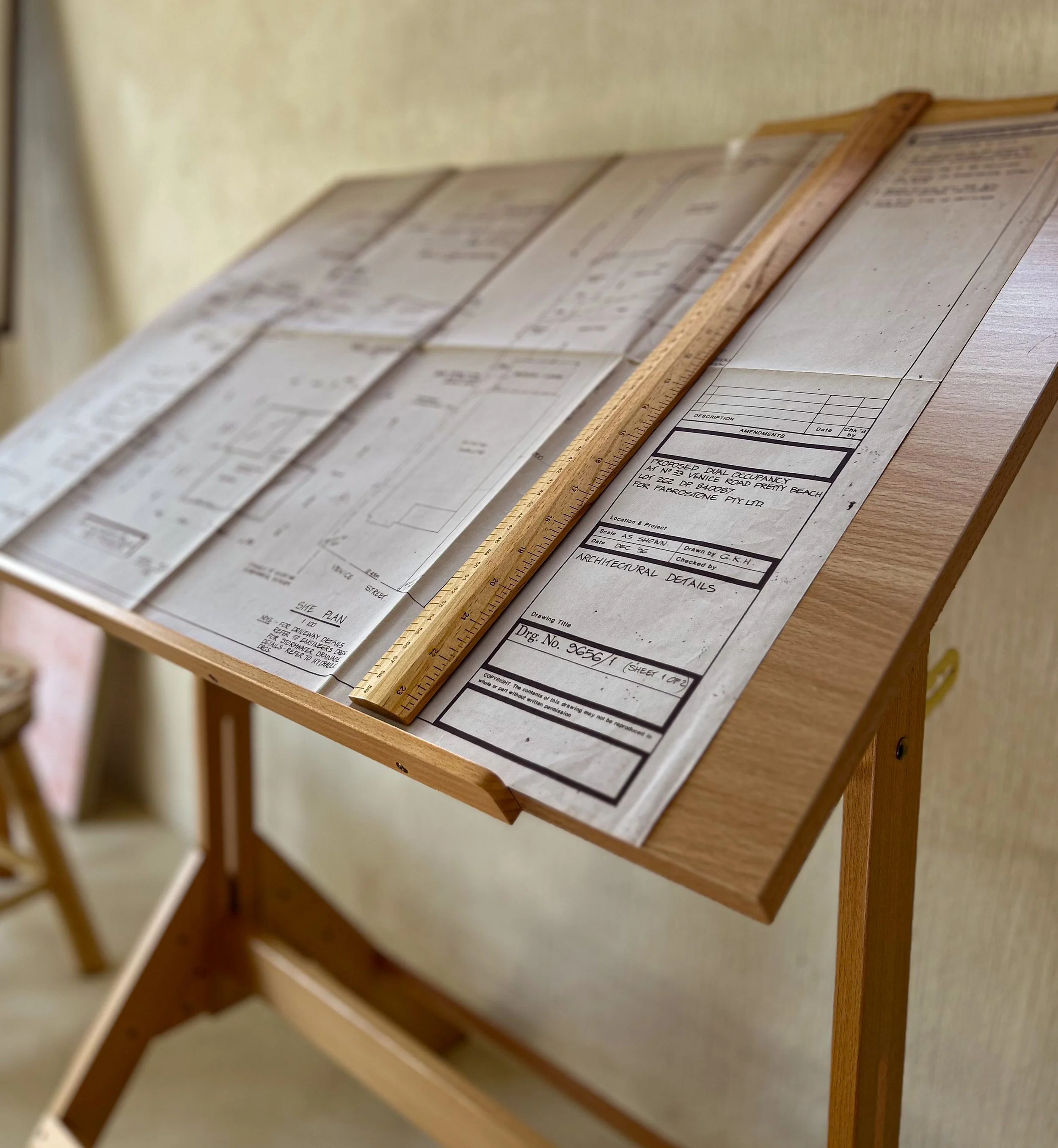 Architectural blueprints and drawings on a wooden stand.
