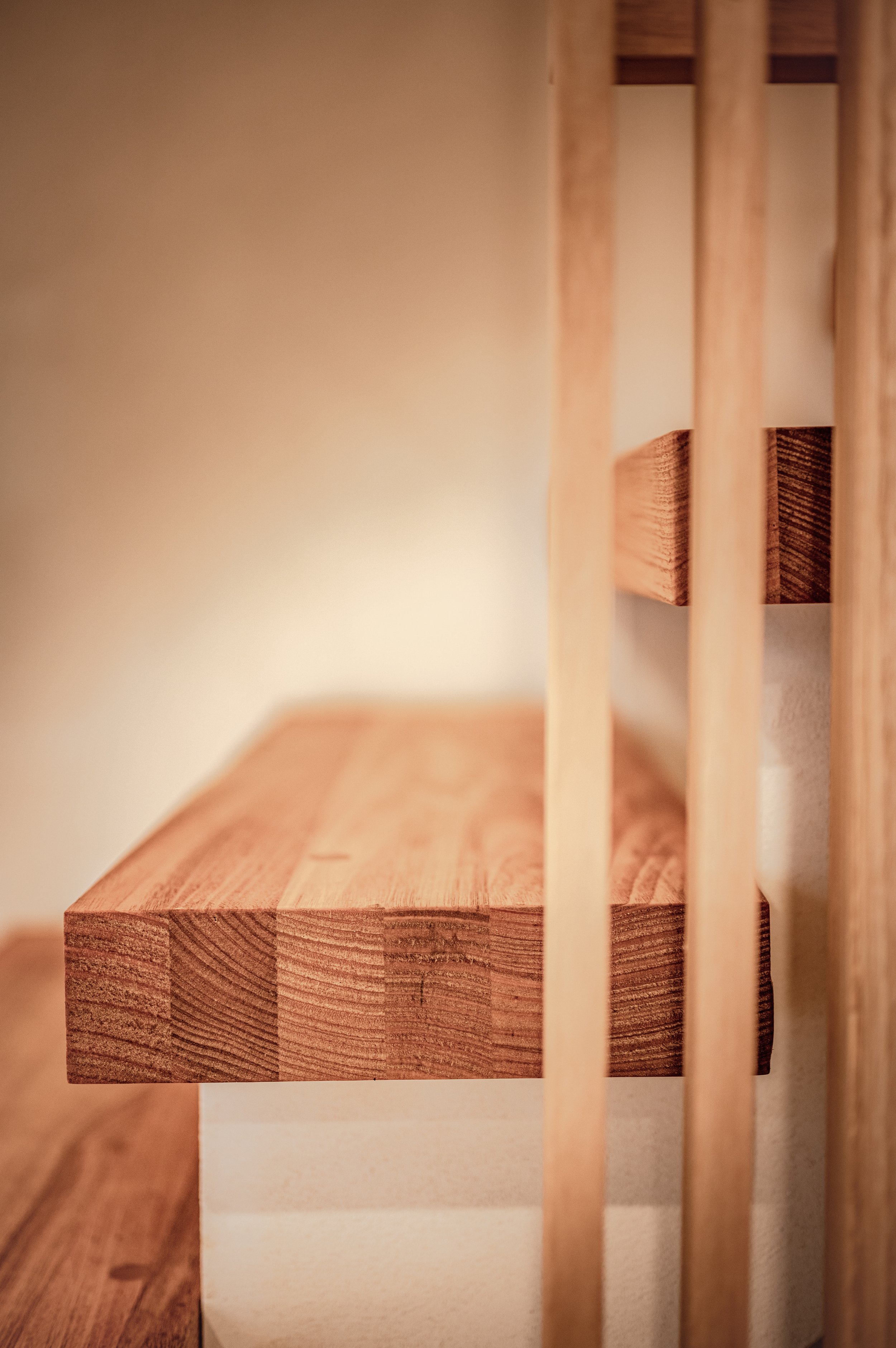 Close-up of wooden furniture with slats, possibly a cabinet or shelf, highlighting the grain and texture of the wood.