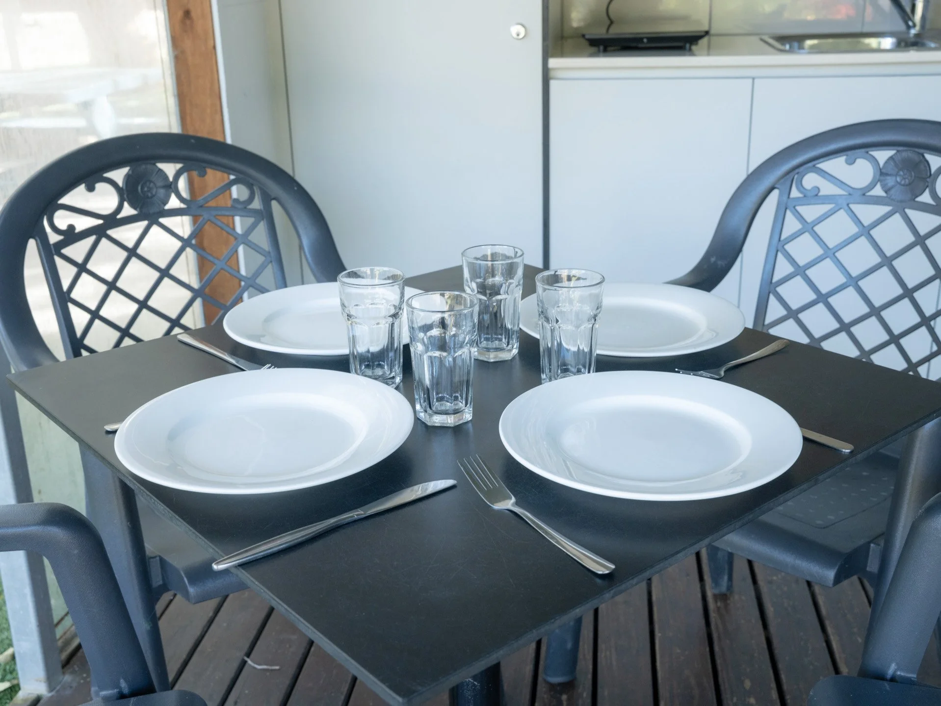 Set the dining table with white plates and cutlery to make the space more lively