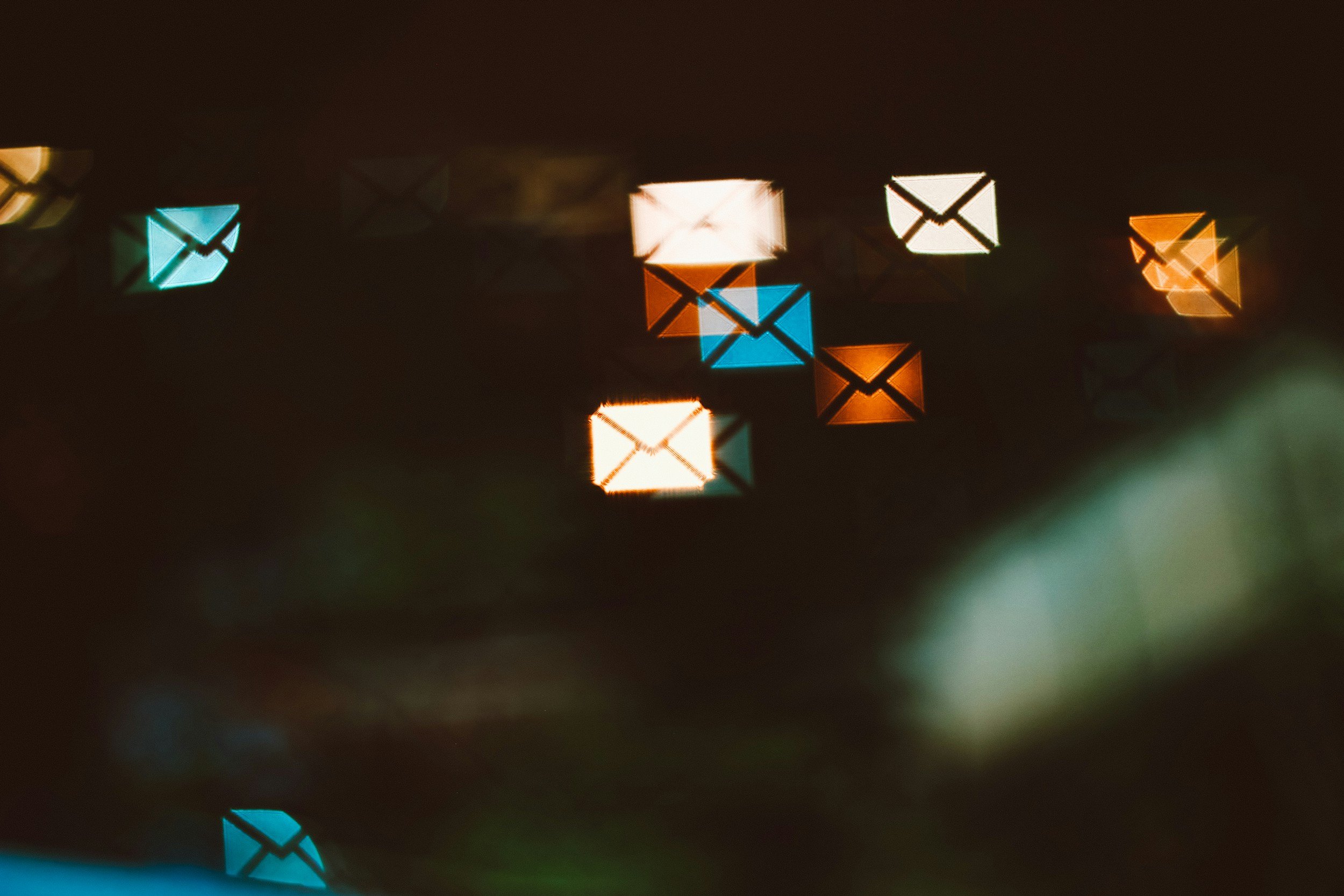 Close-up of illuminated, colorful arrow-shaped lights against a dark background.