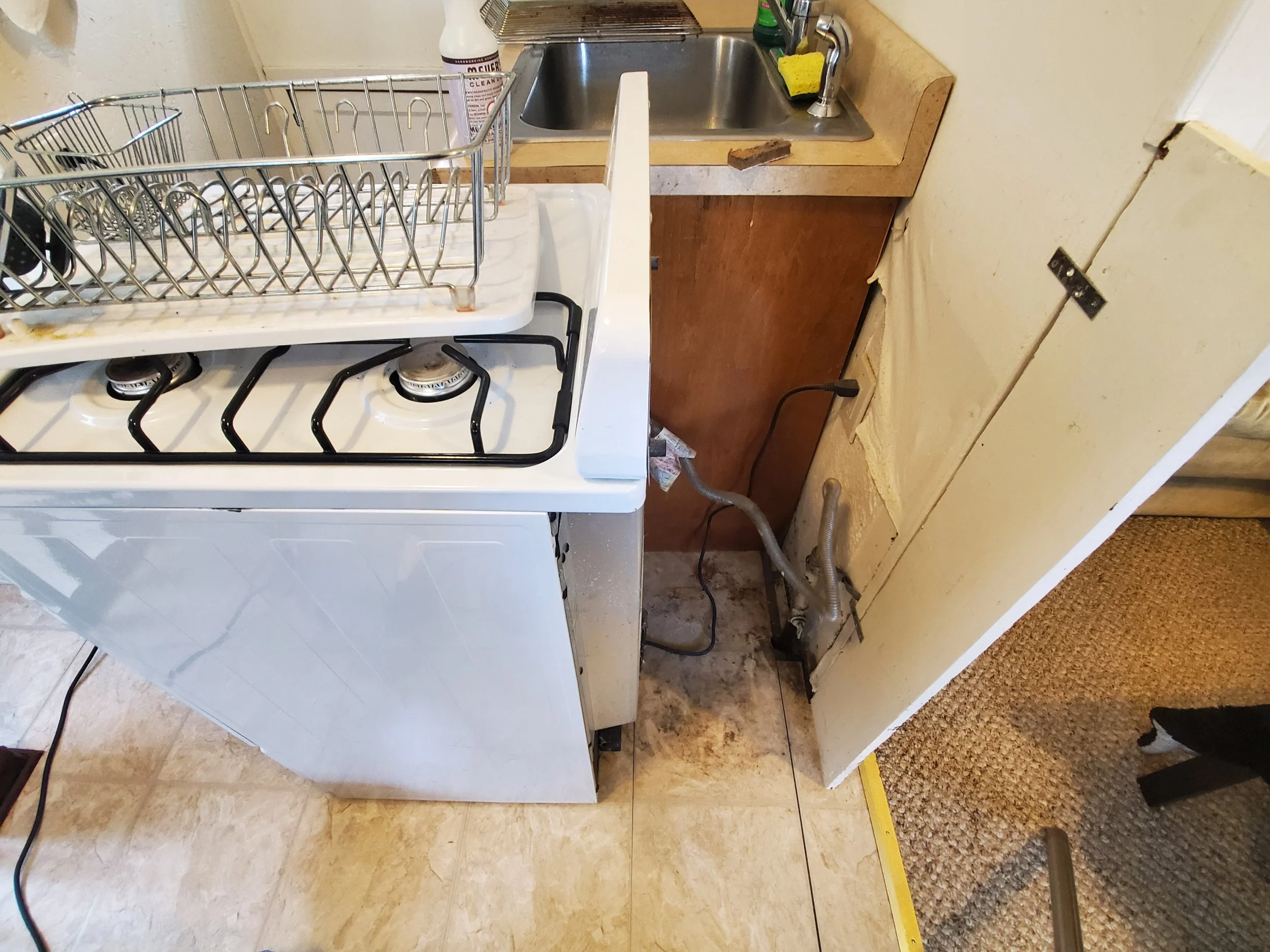 Floor behind stove with dust and debris -BEFORE DEEP CLEANING
