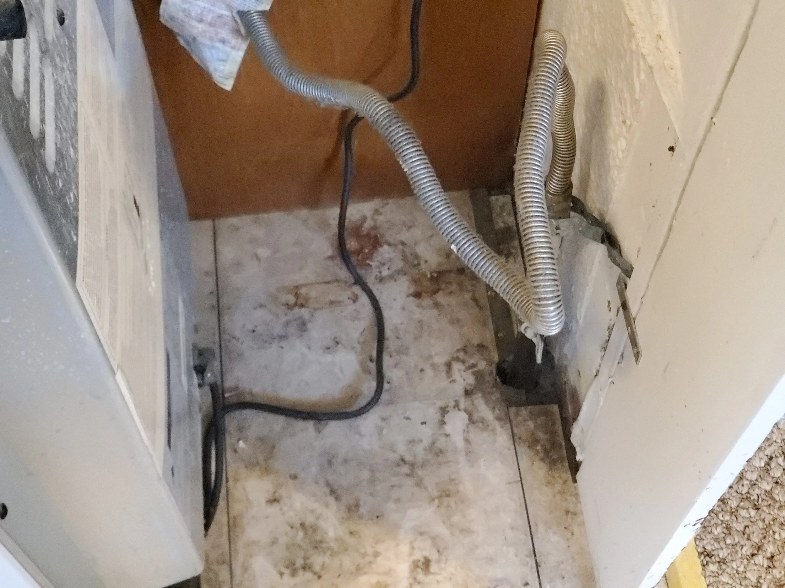 Floor behind stove with dust and debris -BEFORE DEEP CLEANING