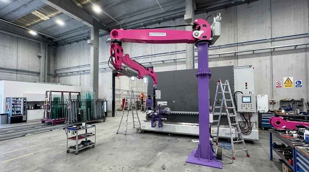 Un robot industriale di colore rosa e viola in un'officina