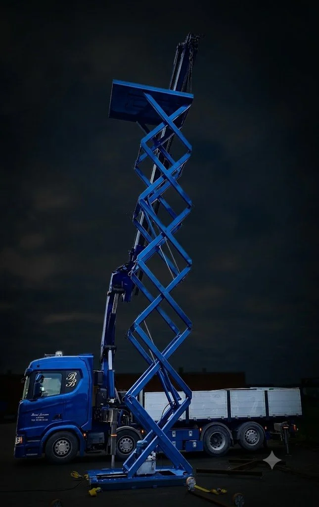 Un'autoscala blu estesa di notte, montata su un camion con cassone bianco.