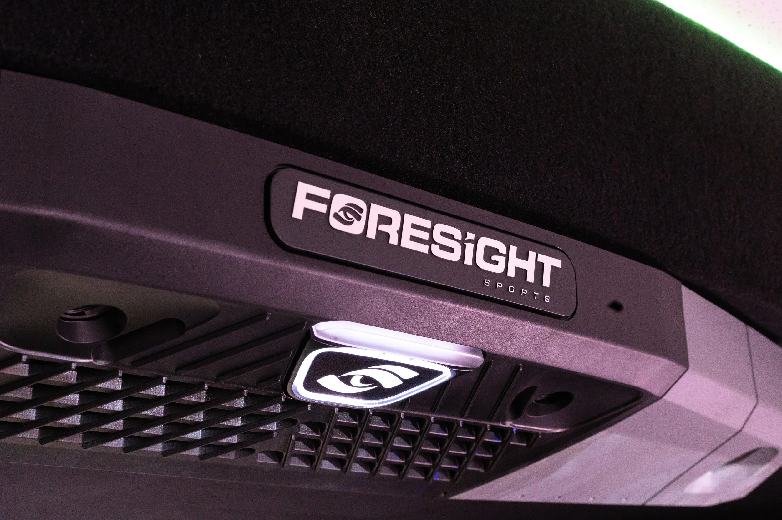 Close-up of a Forensic Sports gaming machine, showing part of its logo and the front grill with a black mesh design.