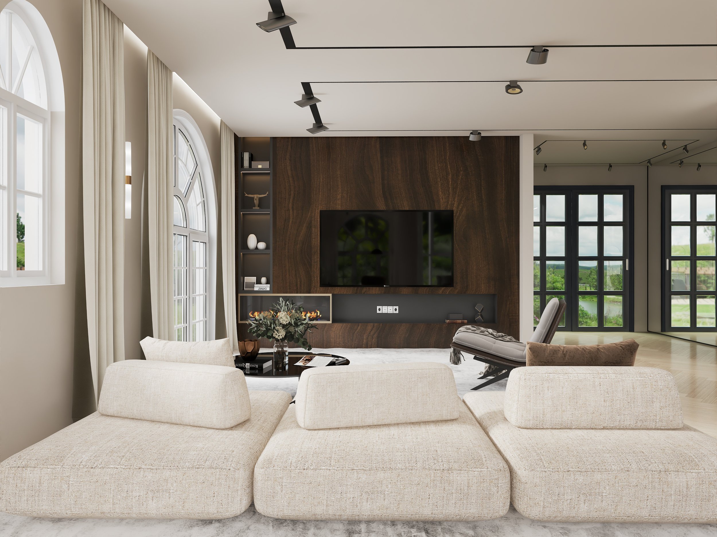 Ein moderner, heller Wohnraum mit großen Fenstern, weißen Vorhängen, einem schwarzen Fernseher vor einer dunklen Holzverkleidung, einem Kamin, einem Blumenarrangement und mehreren bequemen weißen Sitzmöbeln.