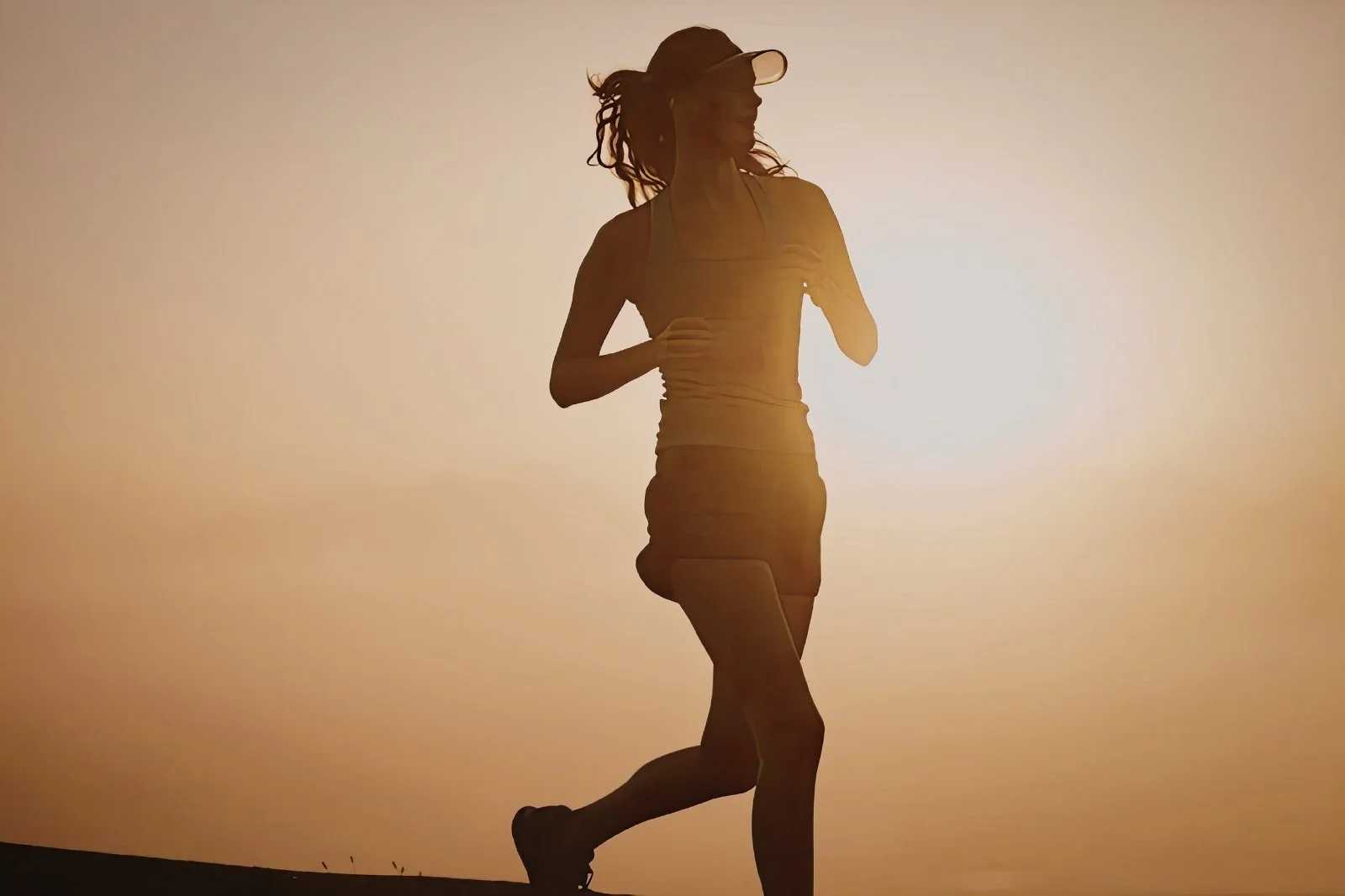Silhouette of a woman running at sunrise or sunset
