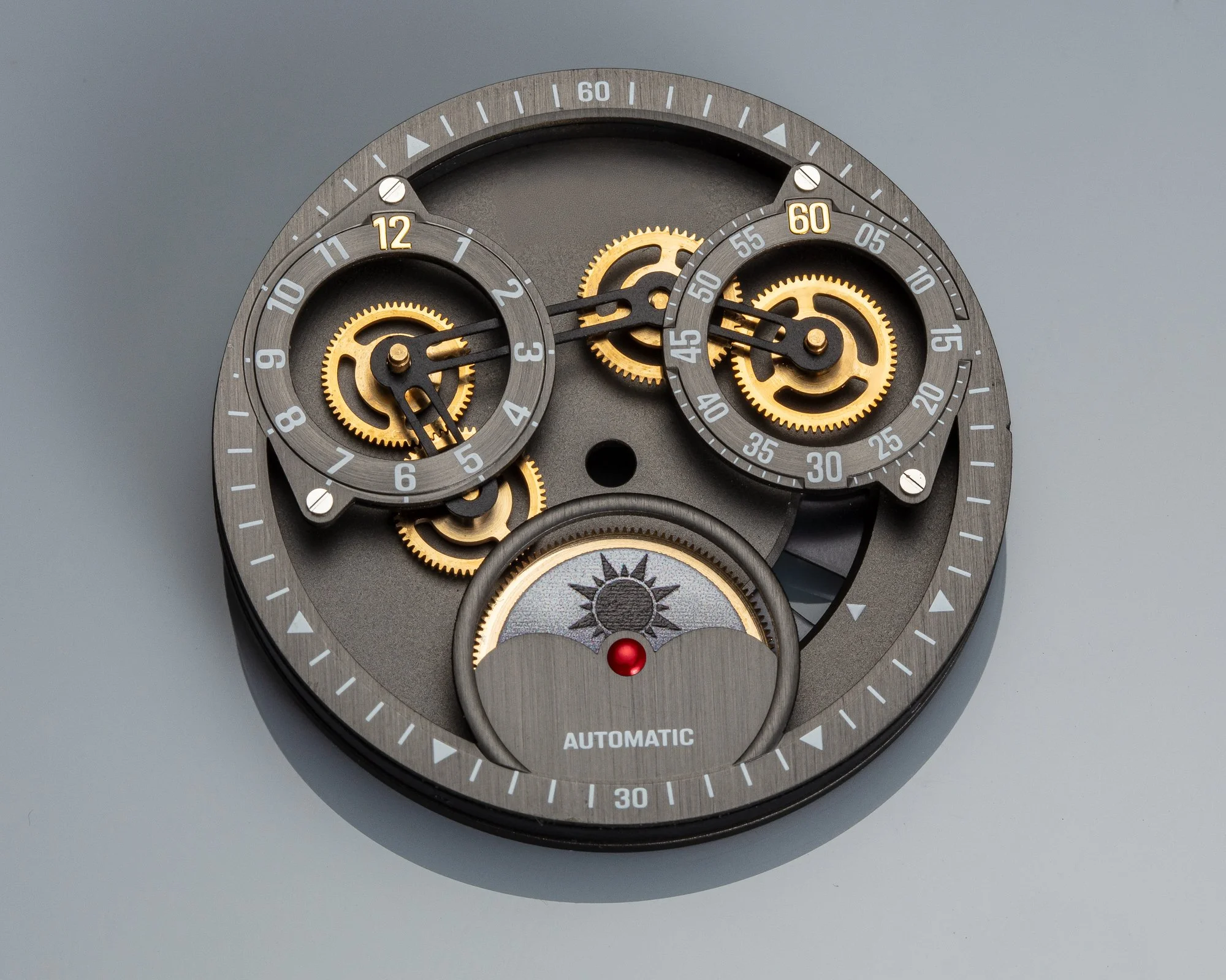 Close-up of a modern, mechanical wristwatch with multiple dials, gears, and an 'automatic' label, showing the inner workings and time indications.