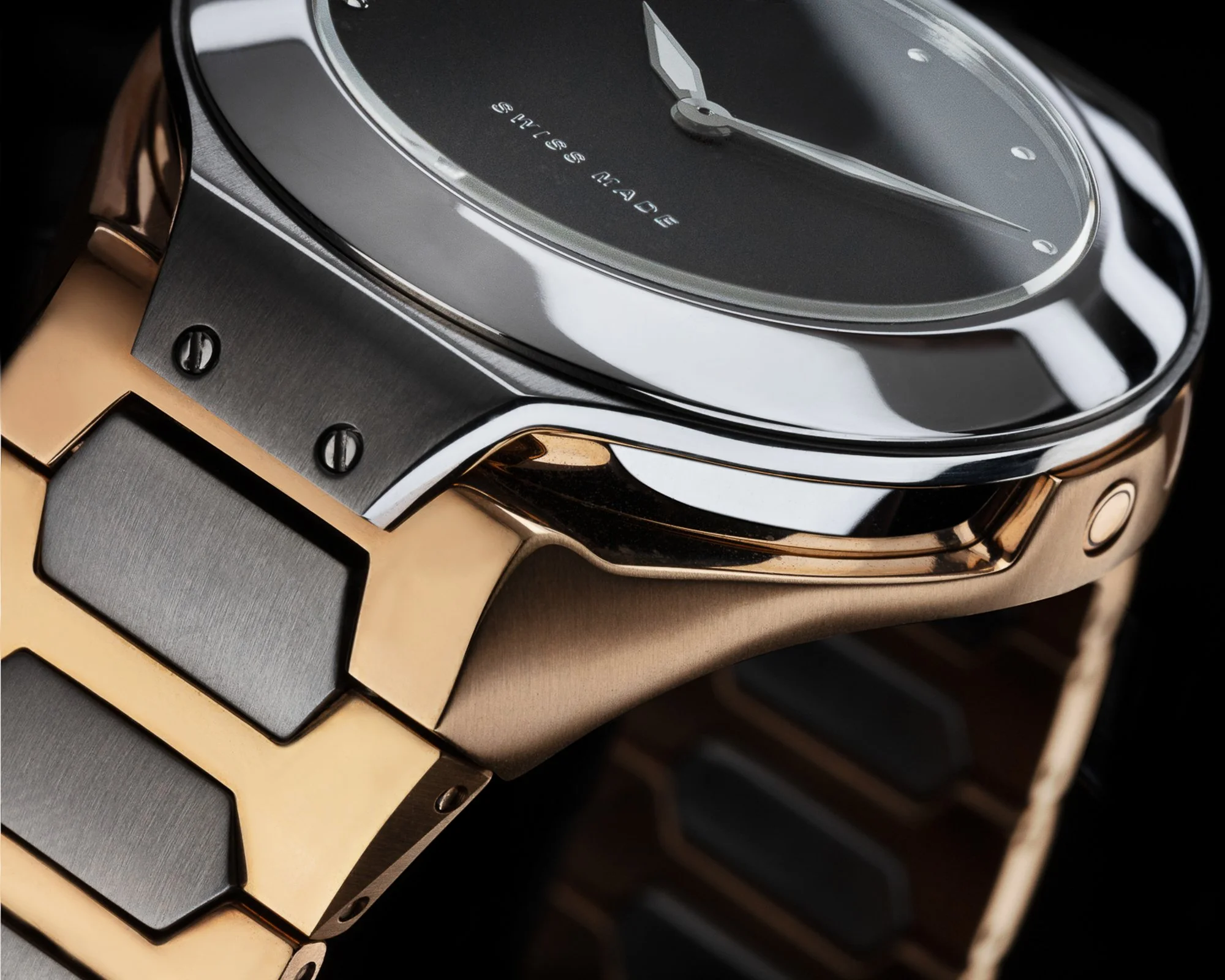 Close-up of a luxury watch with a black dial, silver case, and gold and silver bracelet.