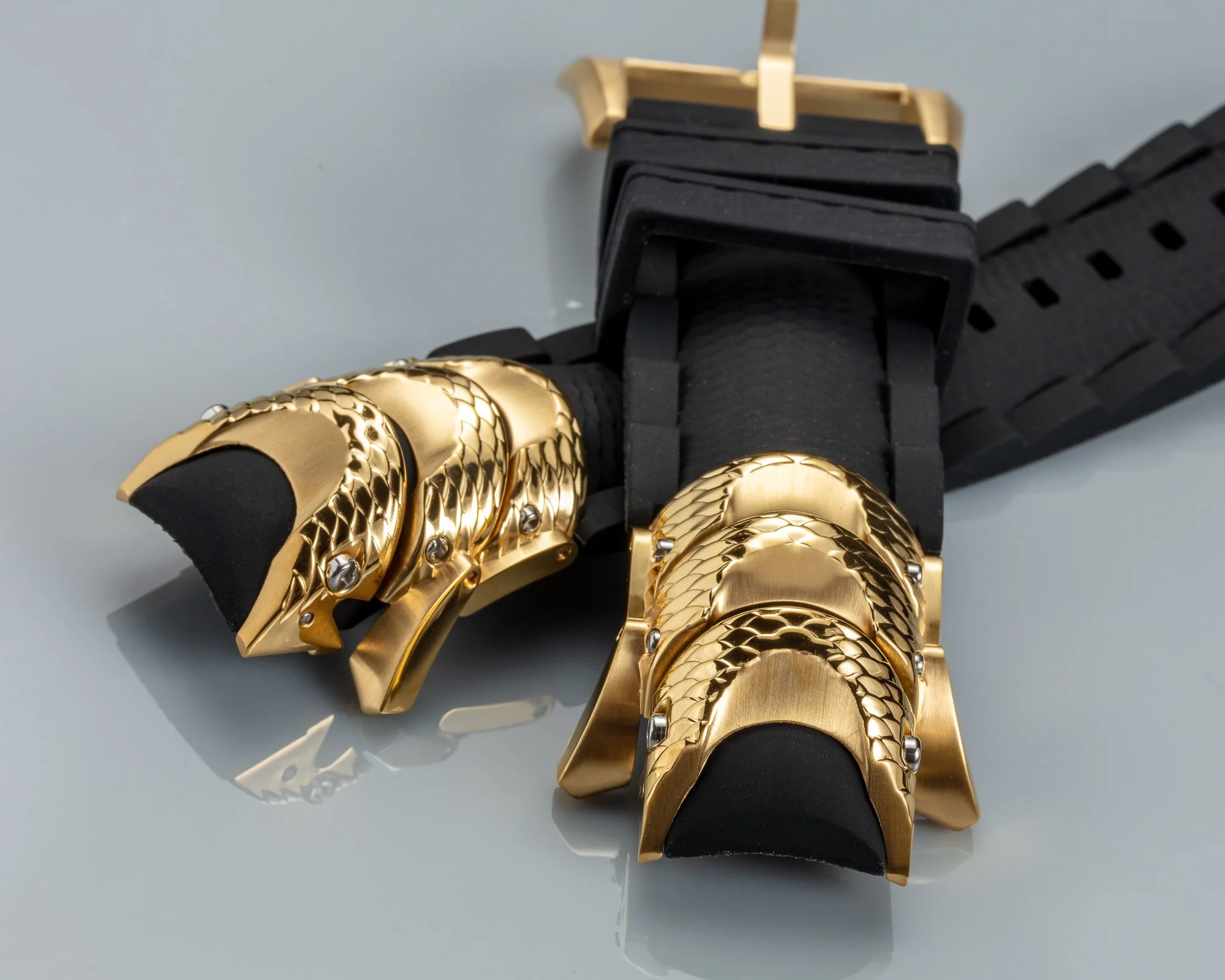 Close-up image of a black and gold metallic jewelry roll holder with multiple gold rings inside.