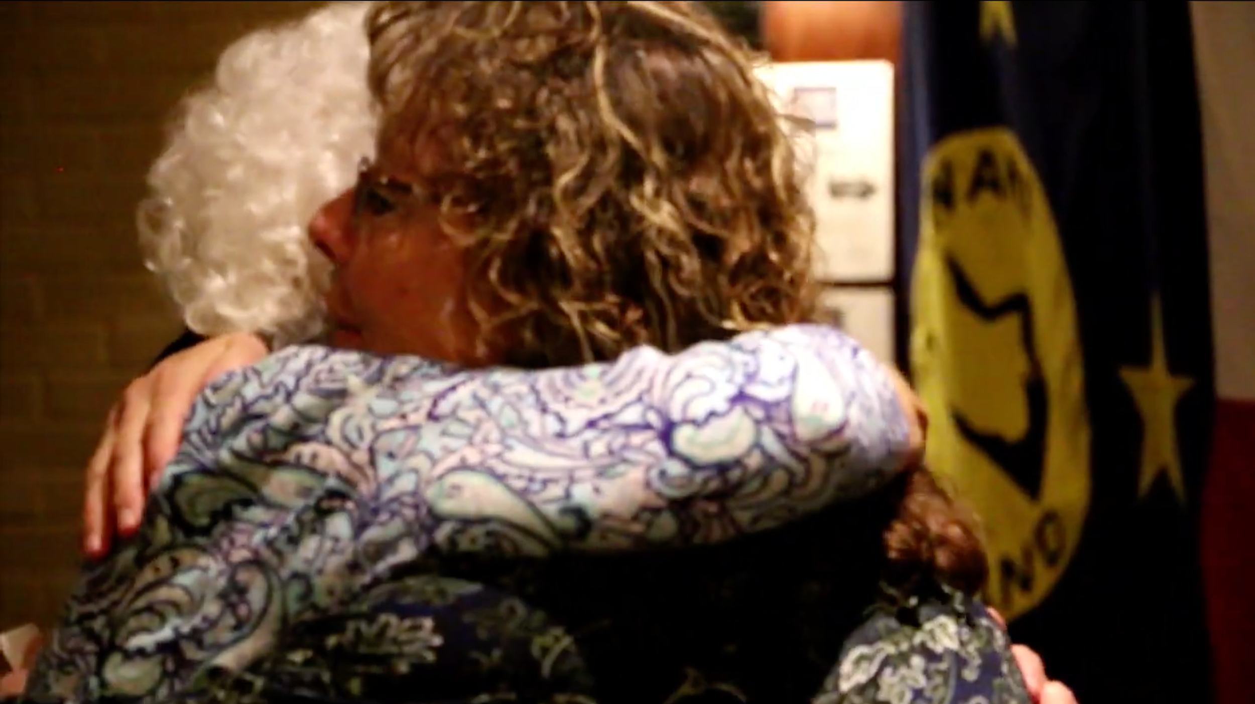 A scene of two Wake Island family members hugging from the upcoming project Workers of Wake.