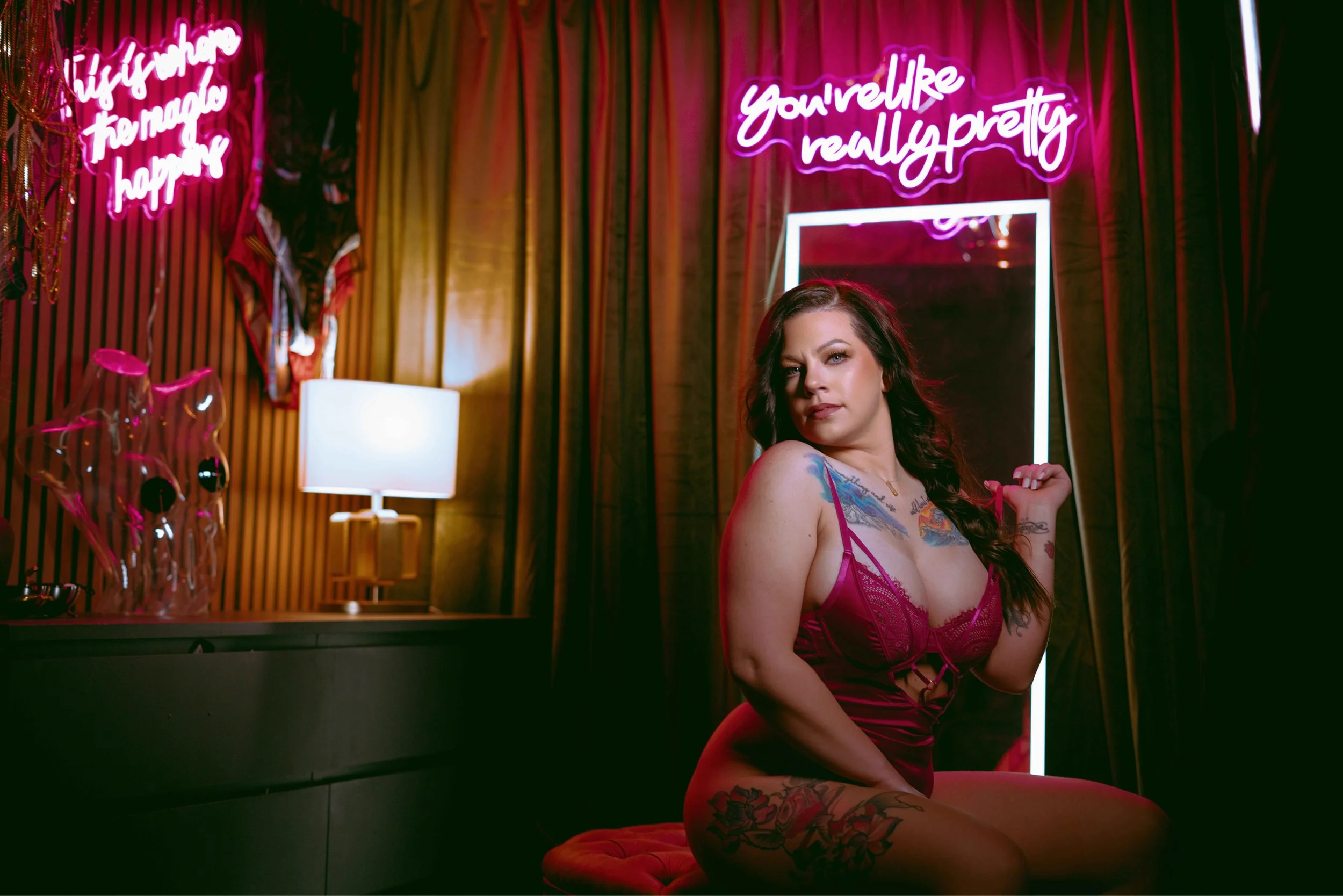 envy boudoir client posing in size inclusive client closet surrounded by neon lights - mesa arizona photographer