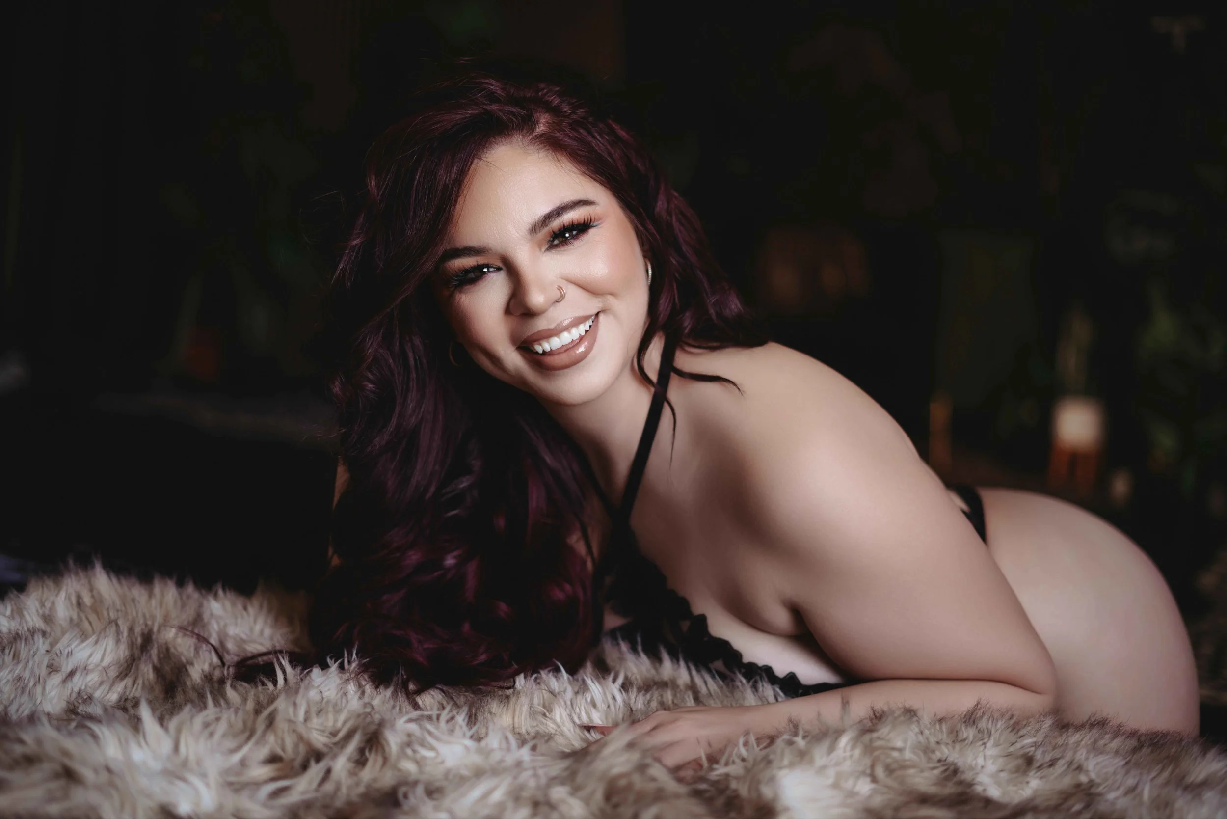 envy boudoir photography client in mesa arizona posing and smiling on fur