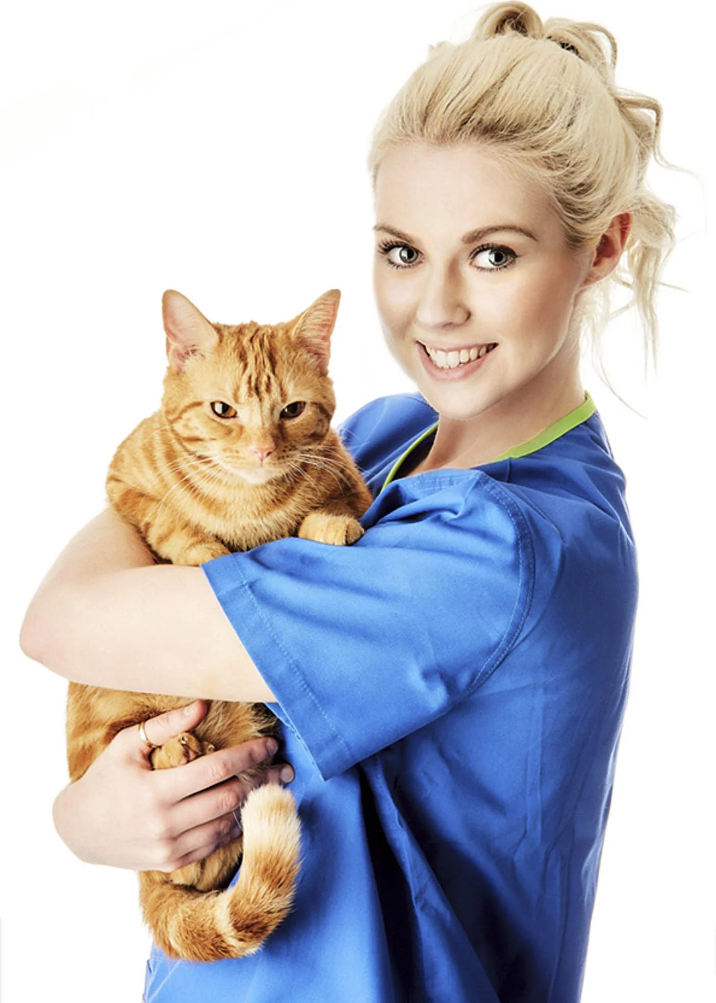 A woman in blue scrubs is holding an orange tabby cat in her arms, smiling at the camera, against a white background.