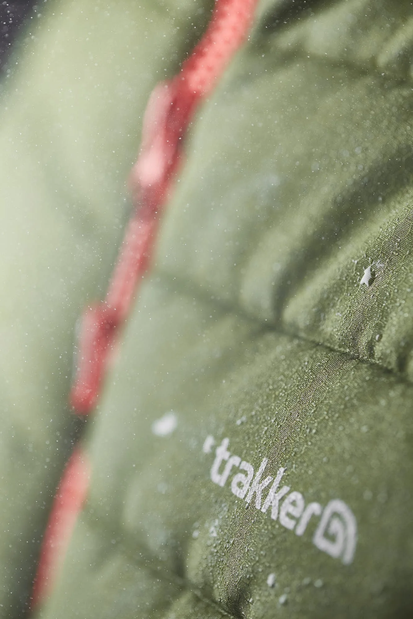Close-up of a green package with red string and white text, with condensation on the surface.