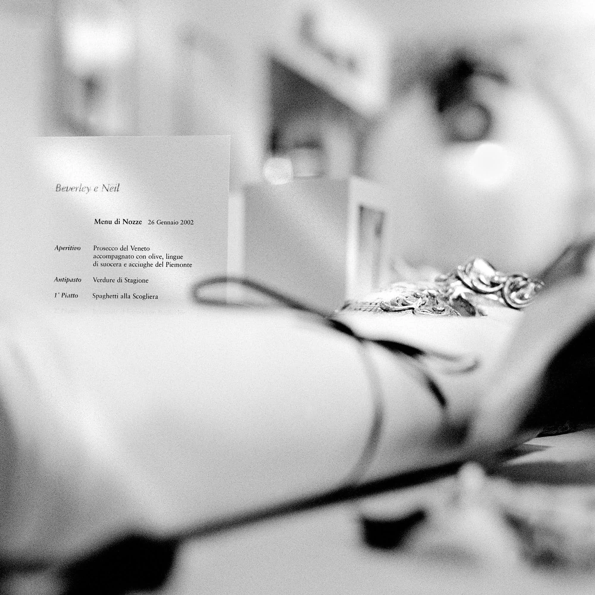 A blurry black and white photograph of a menu with the title 'Beatrice e Neil' and date '26 Gennaio 2002', alongside a blurred image of a wine glass and a plate of spaghetti.