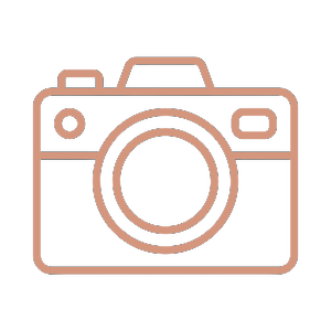 Icon of a camera with a pink outline against a black background.