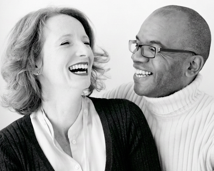 A woman and a man are laughing and smiling at each other, showing joy and connection.