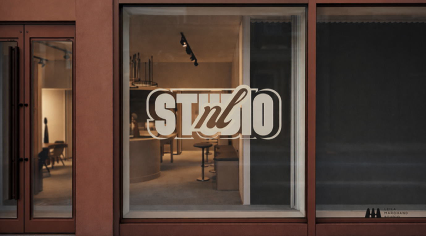 Vitrine d'un studio d'enregistrement avec une signalétique affichant 'STUDIO' sur la vitre, à l'intérieur, des meubles et équipements audio sont visibles.