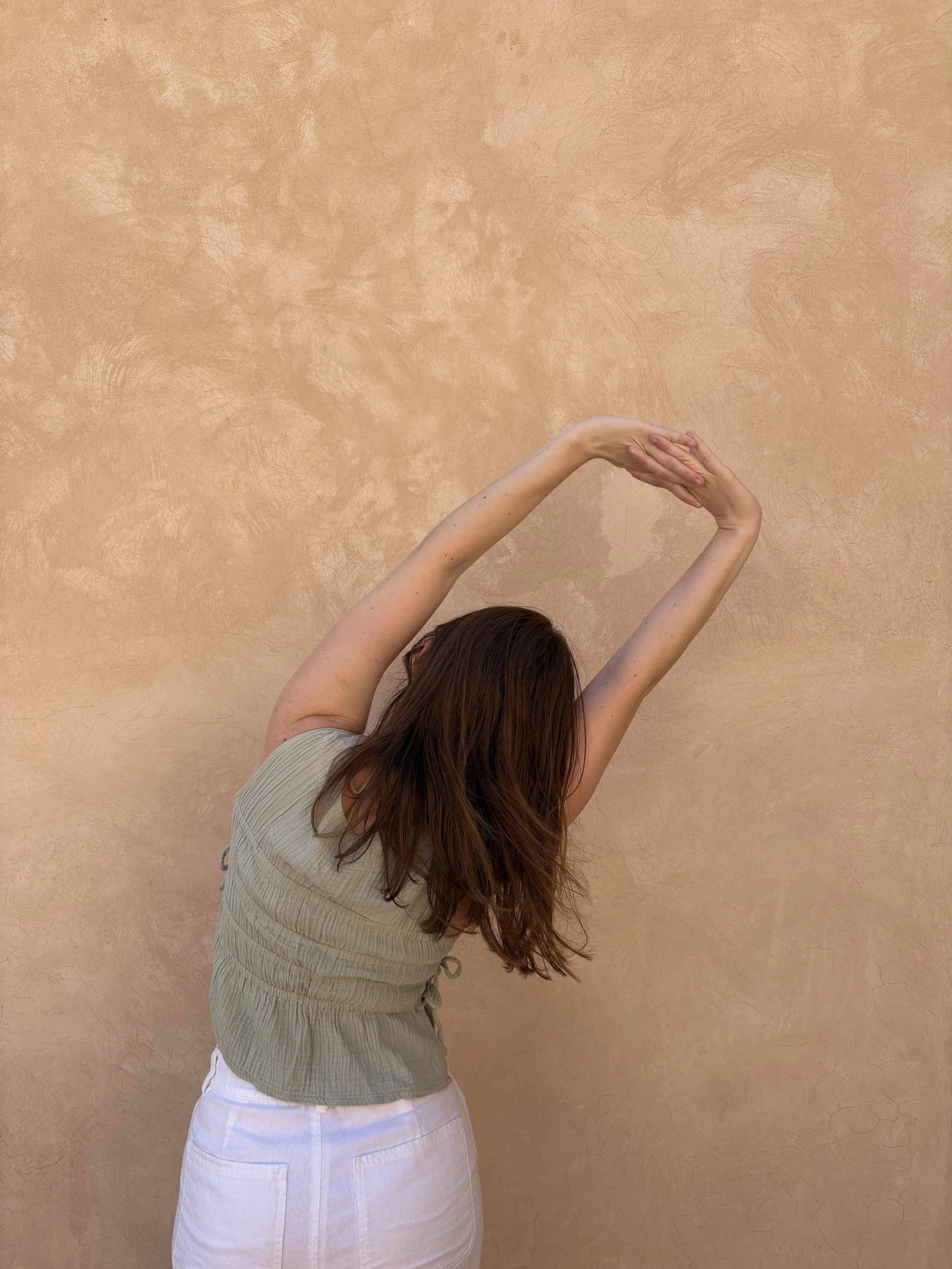 A woman raising her arms above her head in a yoga pose.