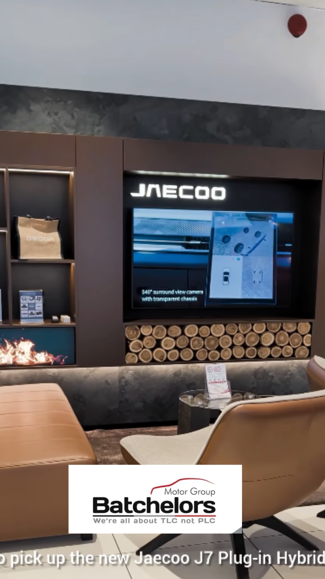 Interior of a showroom featuring a display for JACCO automotive accessories, with a digital screen showing product details, neatly stacked logs below the screen, and modern seating in the foreground. The Batchelors logo and slogan are visible at the bottom of the image.