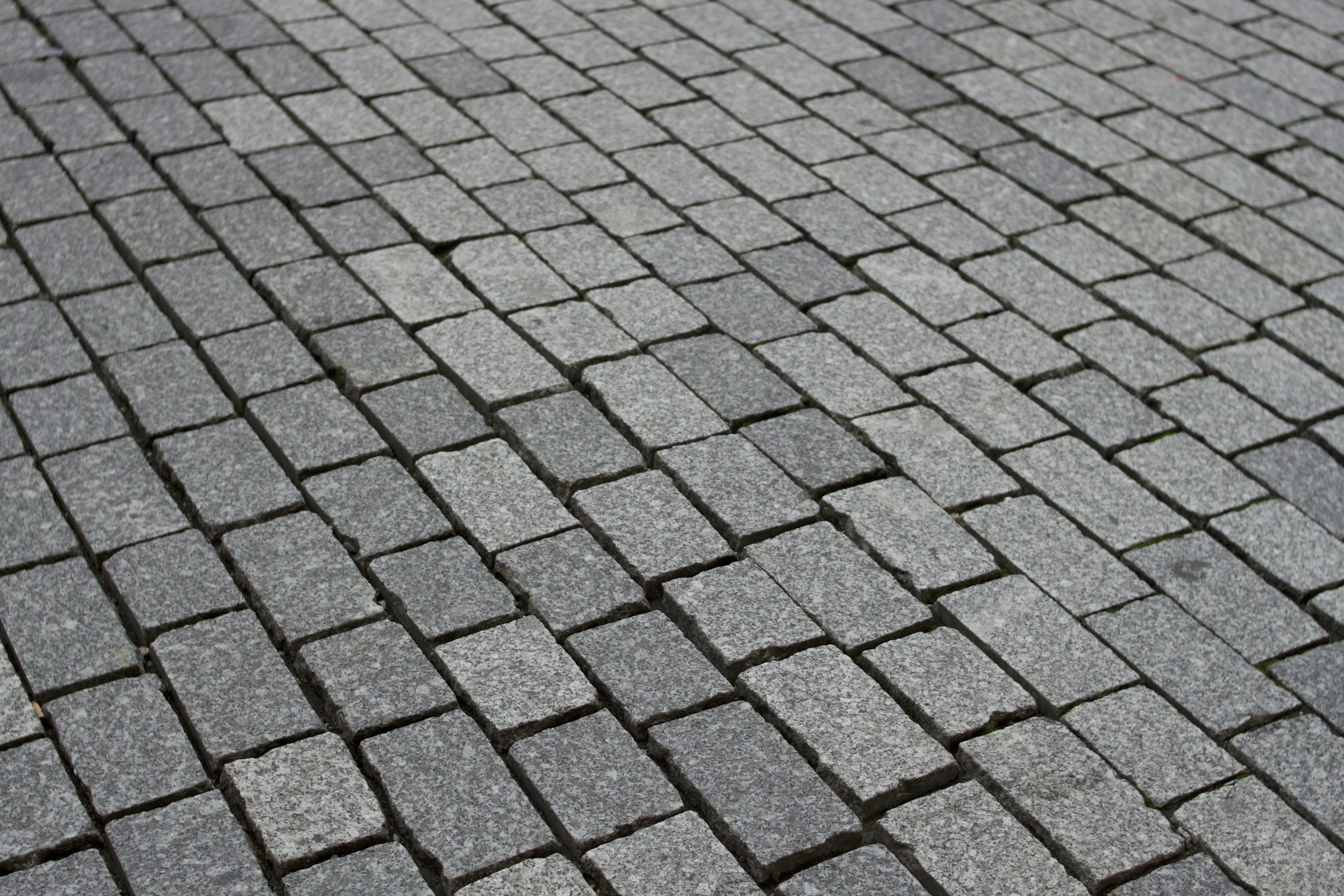 Straßenpflaster aus quadratischen grauen Steinen.