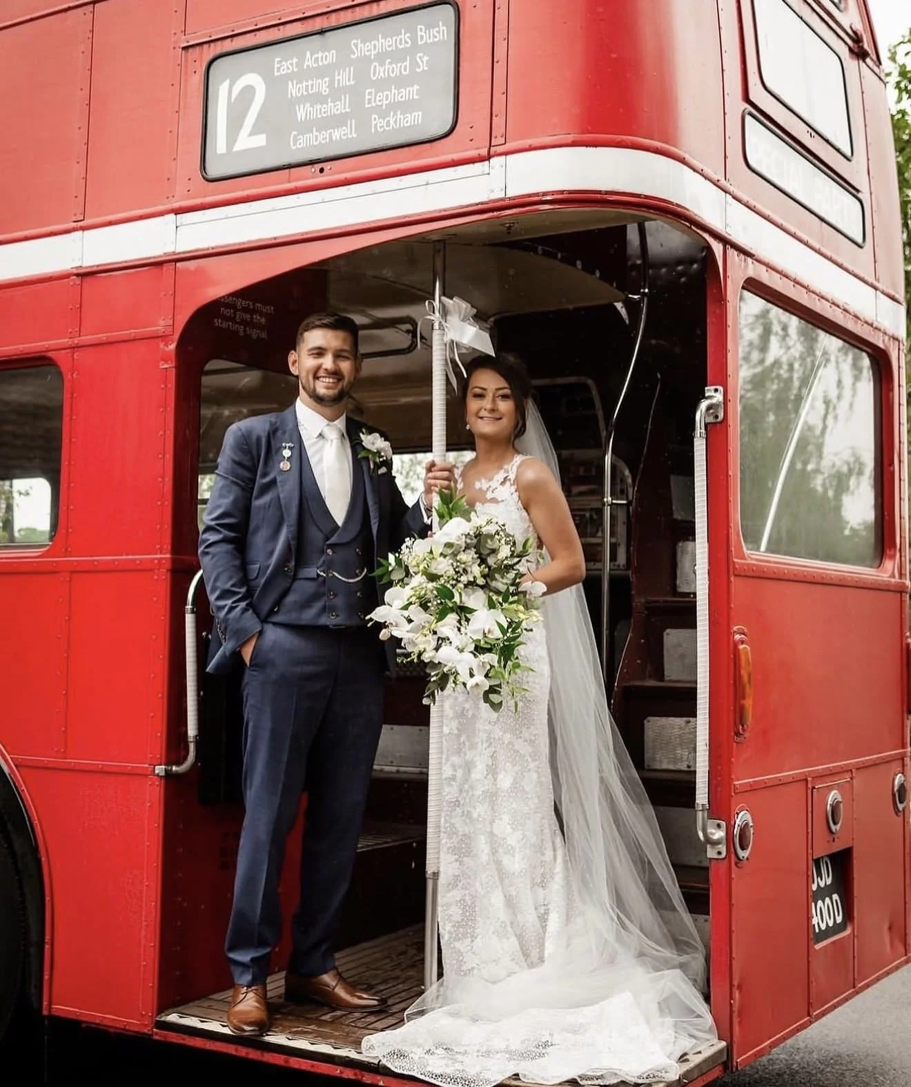 Bride with natural, classic Wedding Make-up and Wedding Hair updo on a red bus.